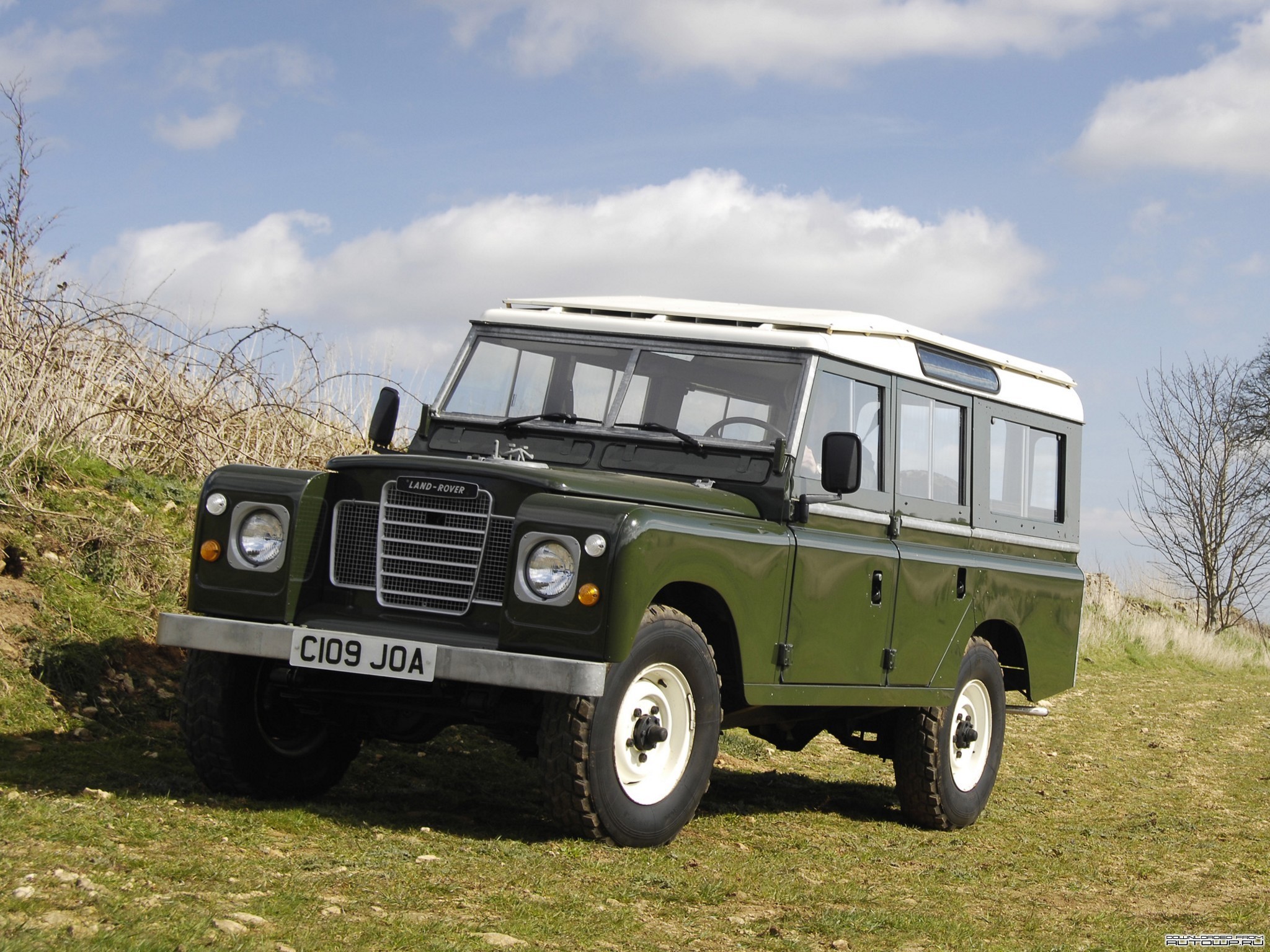 Green Land Rover parked on a grassy hill HD Wallpaper
