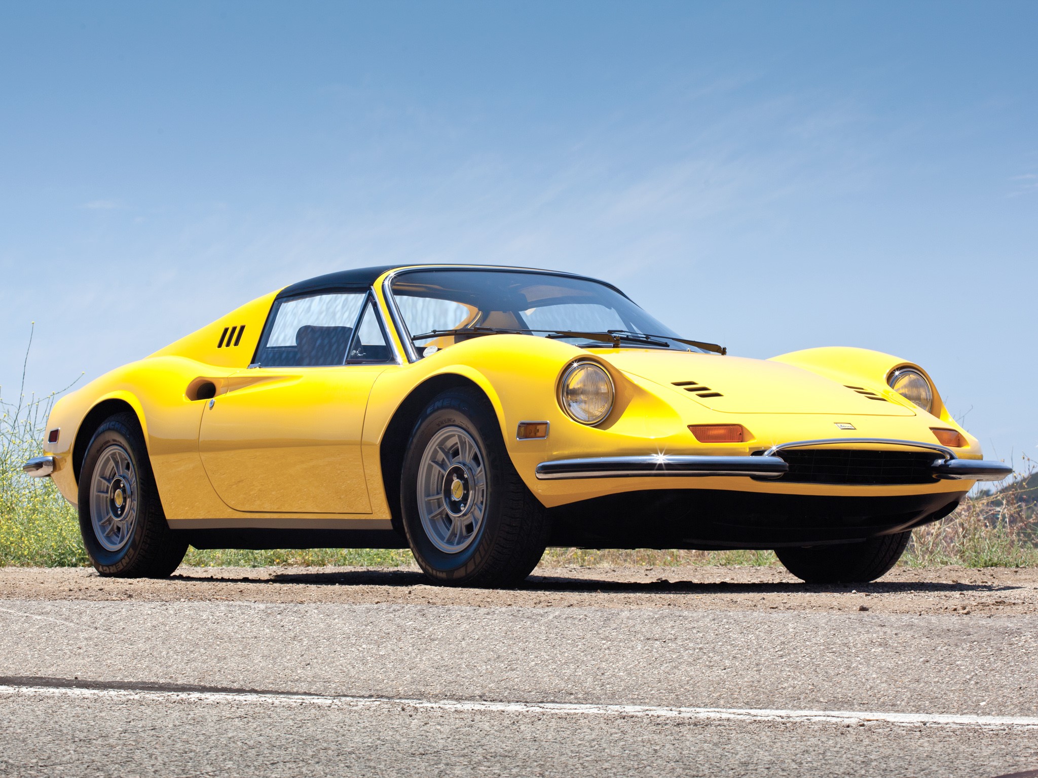 Yellow Ferrari Dino 246 GT parked on a dirt road HD Wallpaper