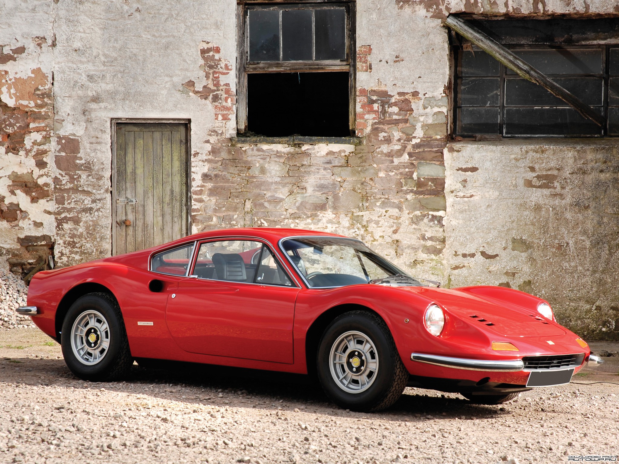 Red Ferrari parked in front of an old brick building HD Wallpaper