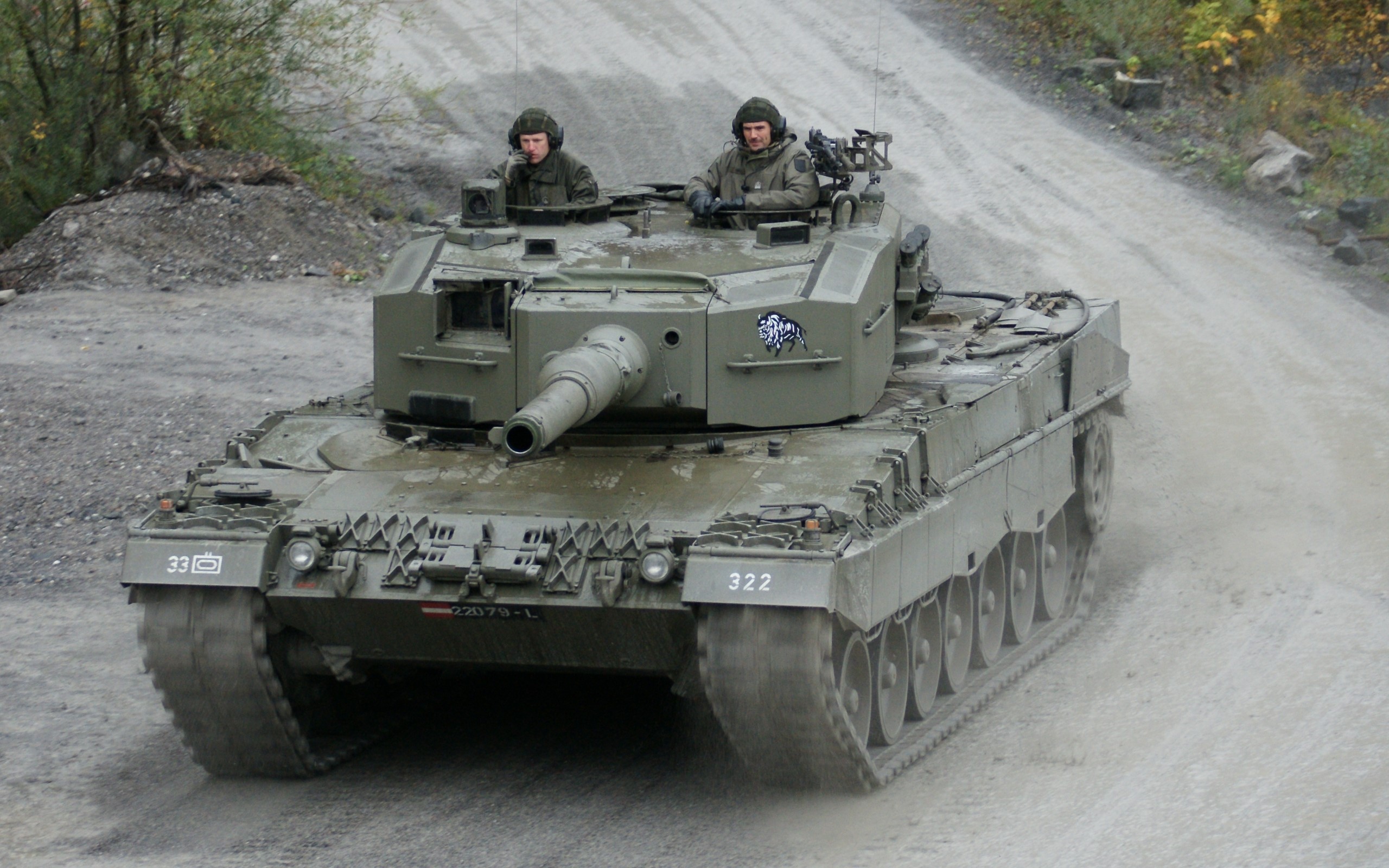 Leopard 2 tank with crew on a dirt road HD Wallpaper