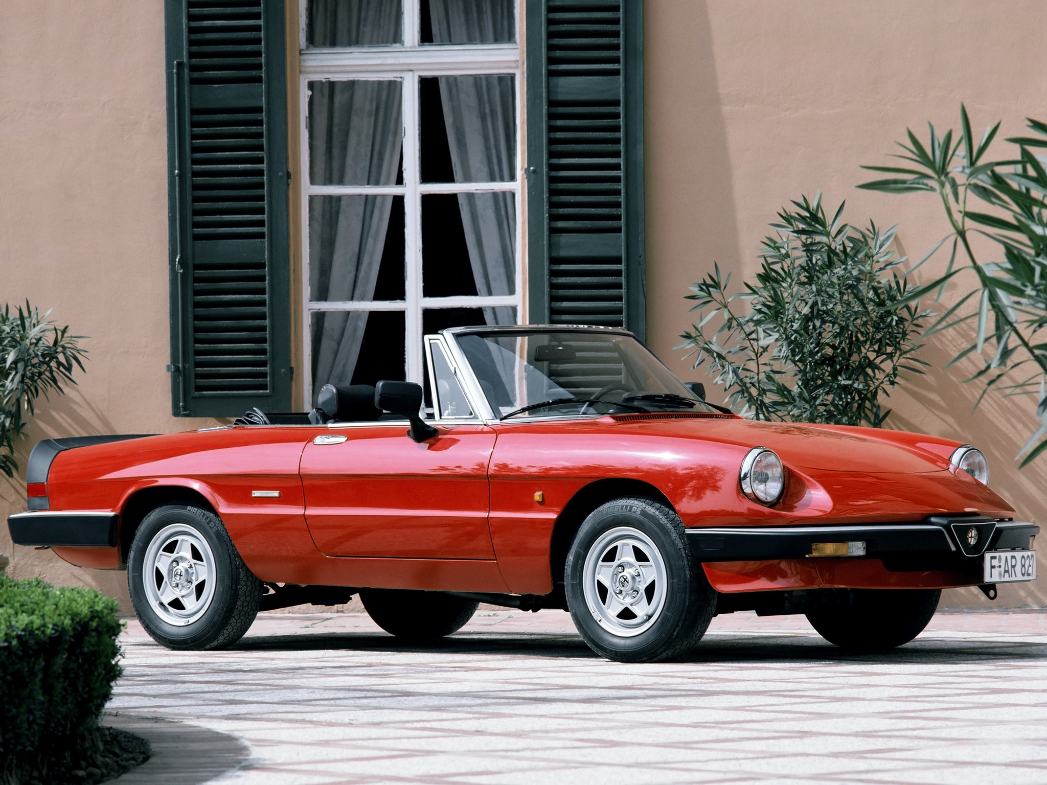 Red Alfa Romeo Spider convertible parked outdoors HD Wallpaper