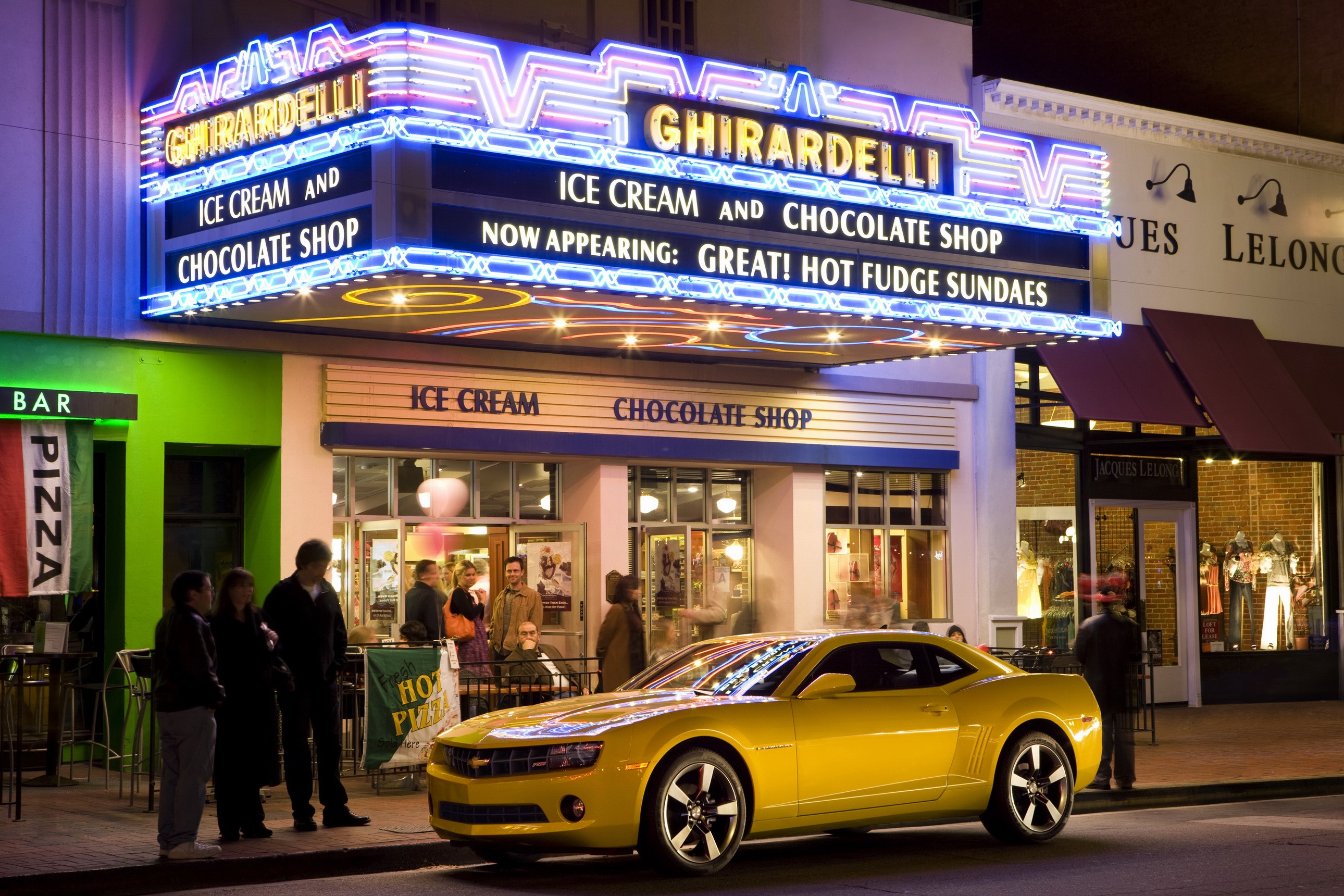 Yellow Chevrolet Camaro in front of Ghirardelli Ice Cream Shop HD Wallpaper