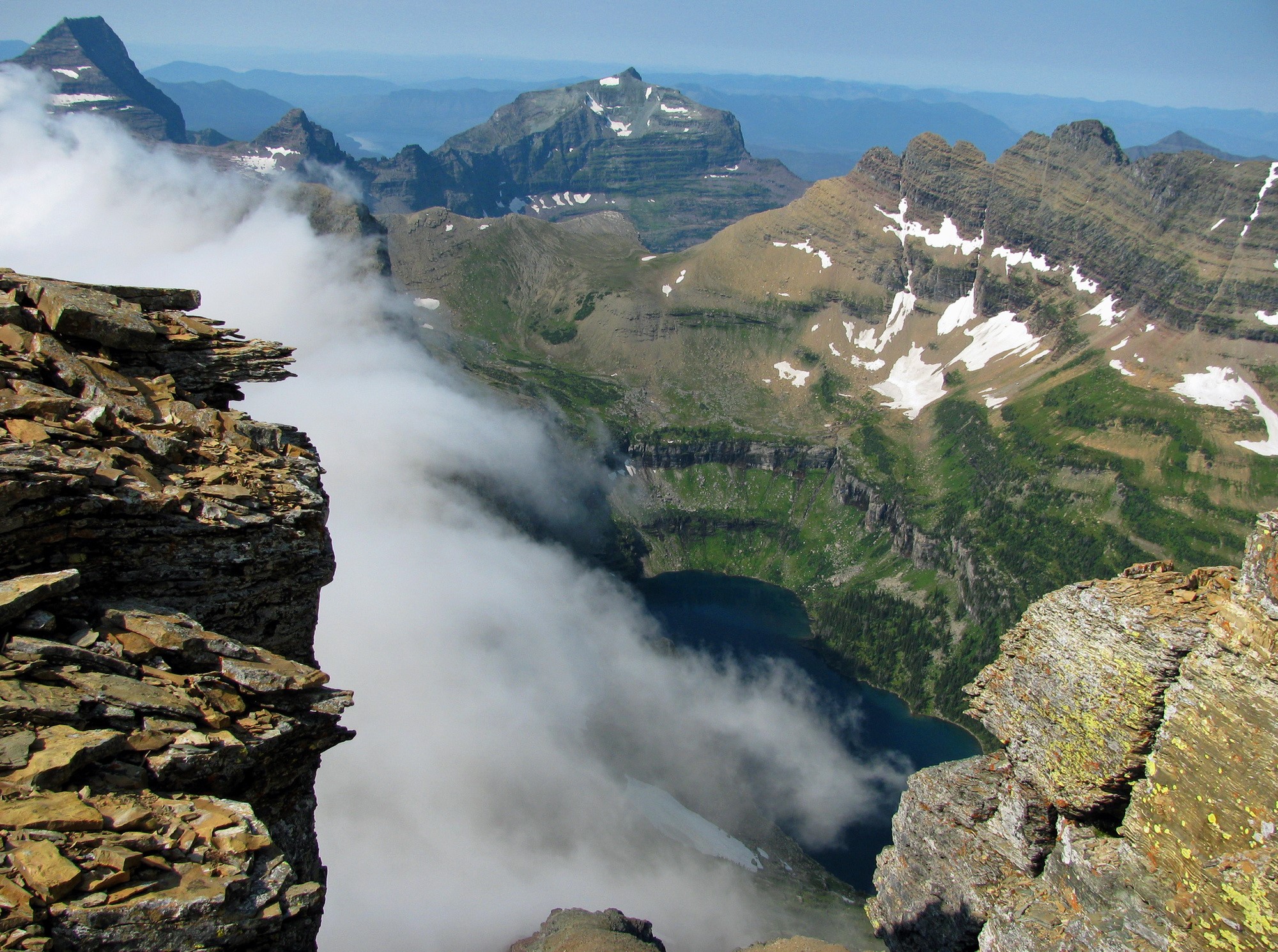 Mountain peaks with clouds and a lake in Glacier National Park HD Wallpaper