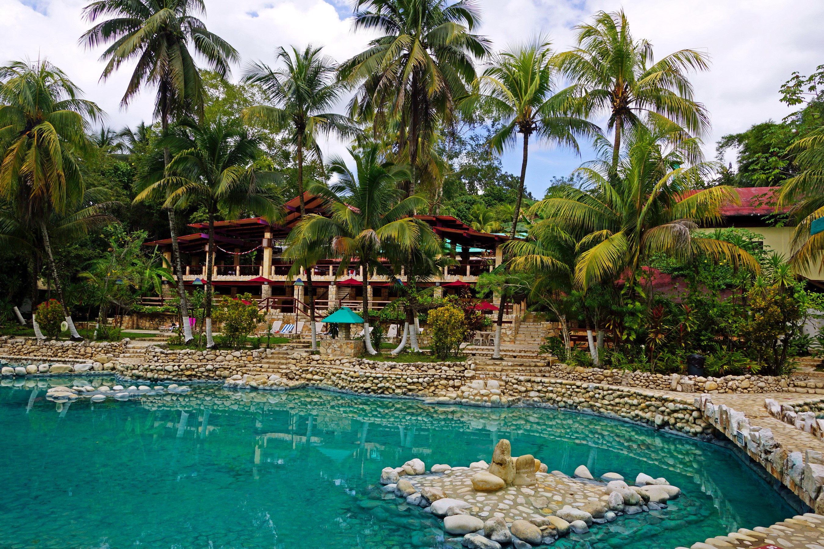 Resort with a pool and palm trees HD Wallpaper