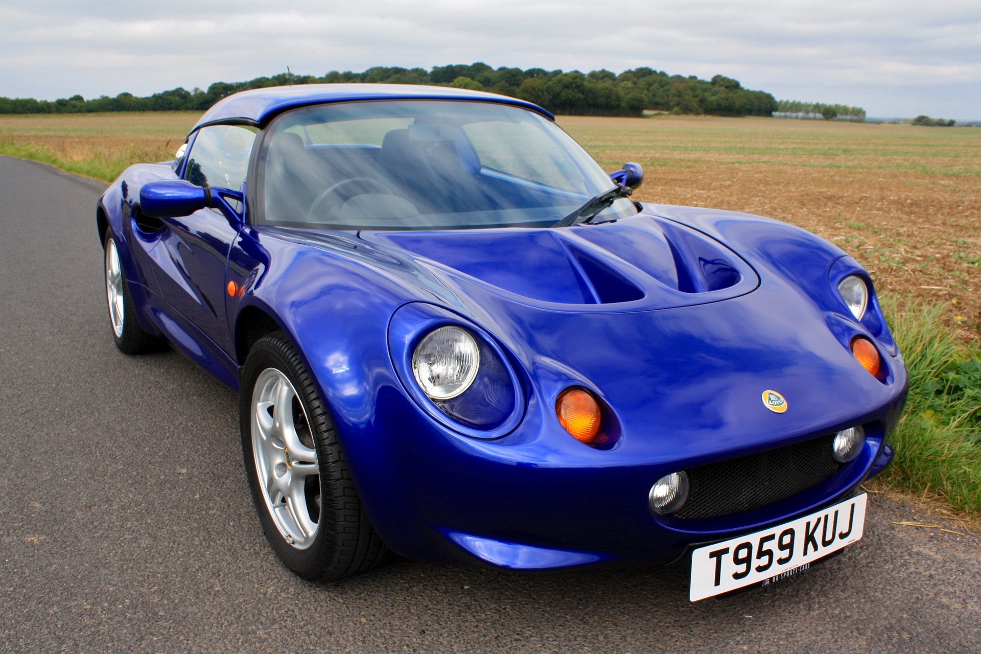 Blue Lotus Elise sports car on a road HD Wallpaper