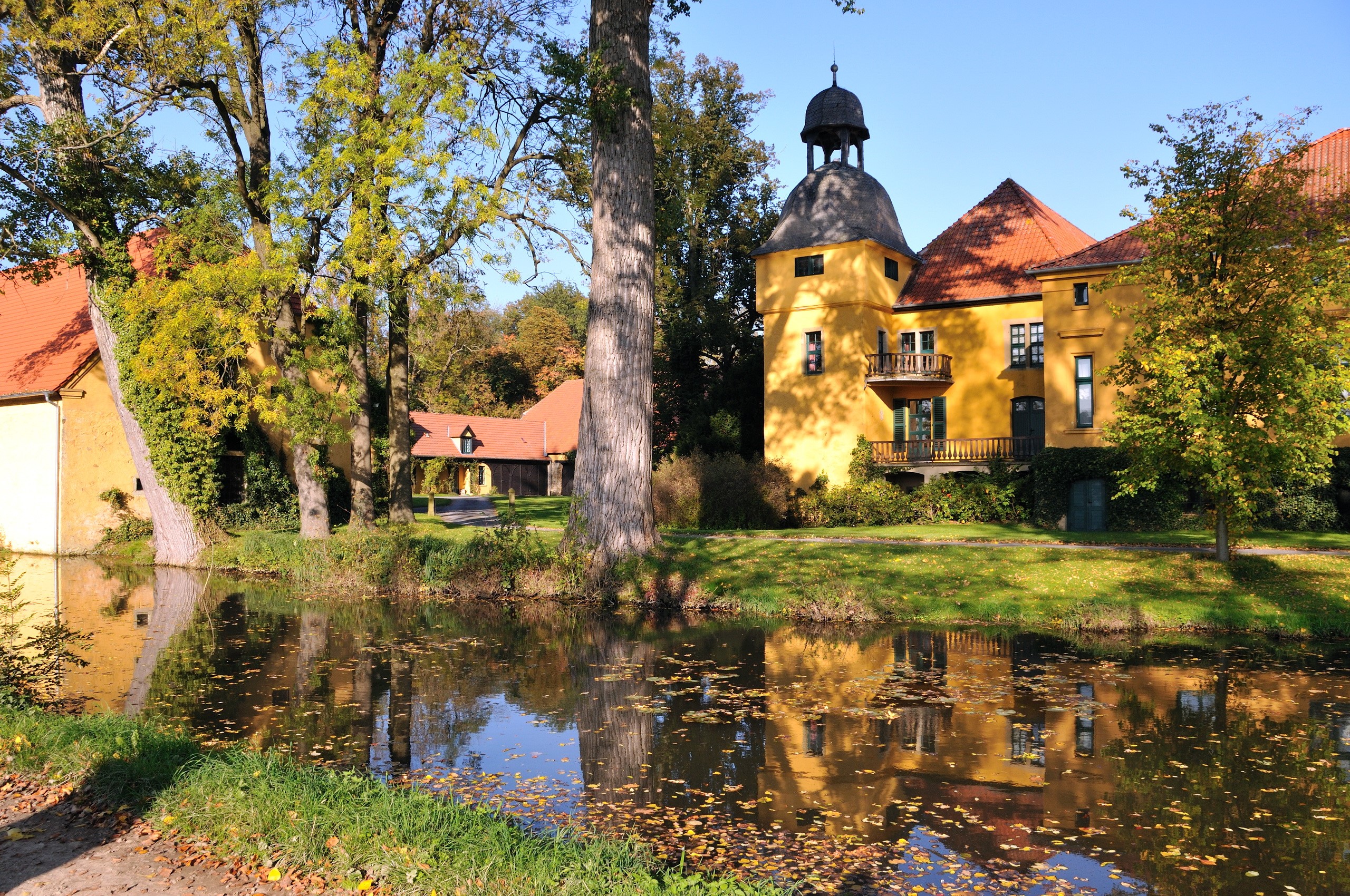 Yellow castle with tower by a pond in Germany HD Wallpaper