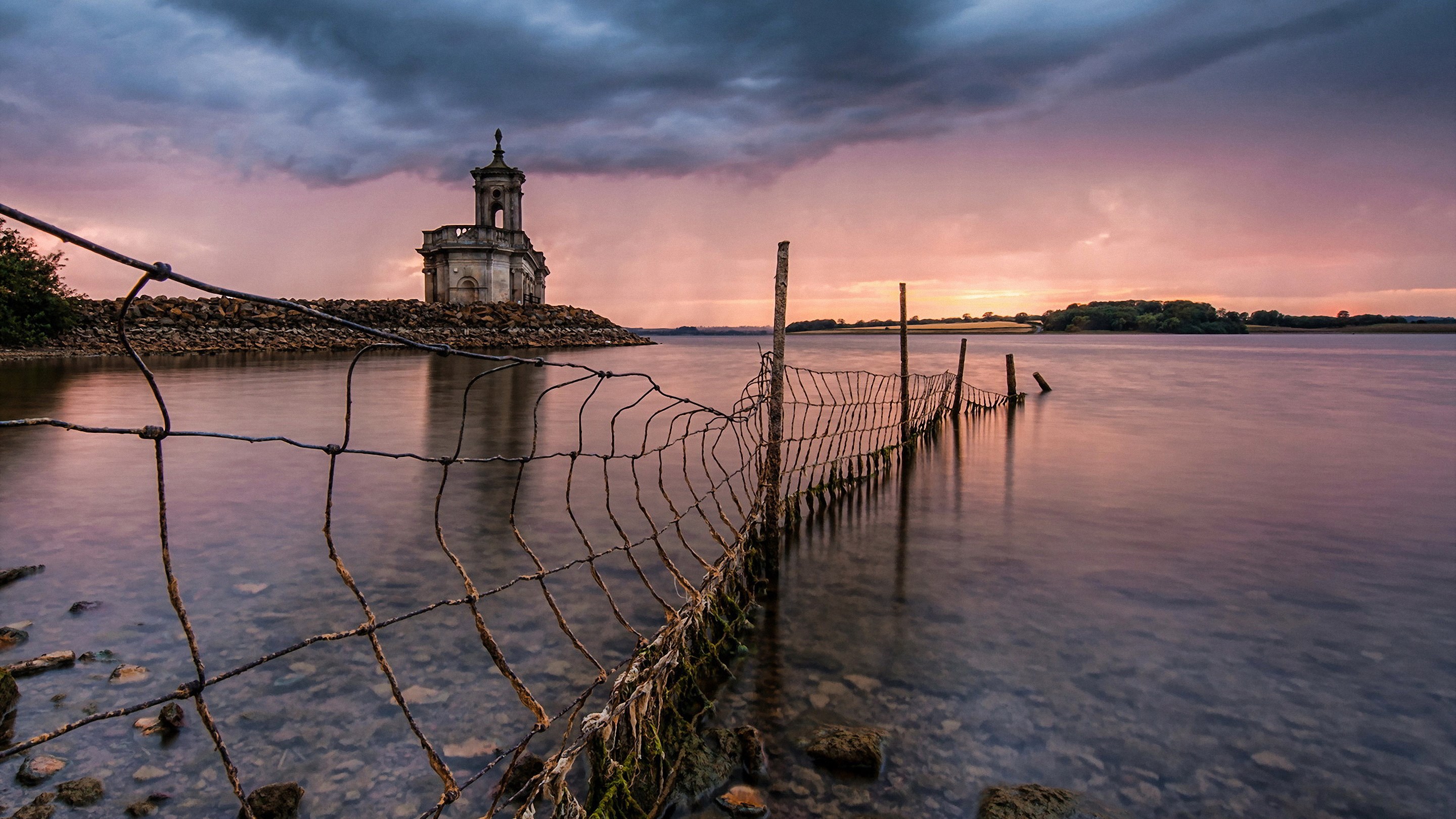 Church on a rocky island in a lake at sunset HD Wallpaper