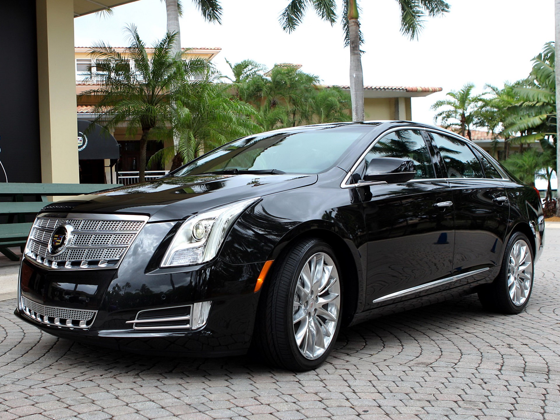 Black Cadillac sedan parked on cobblestone HD Wallpaper