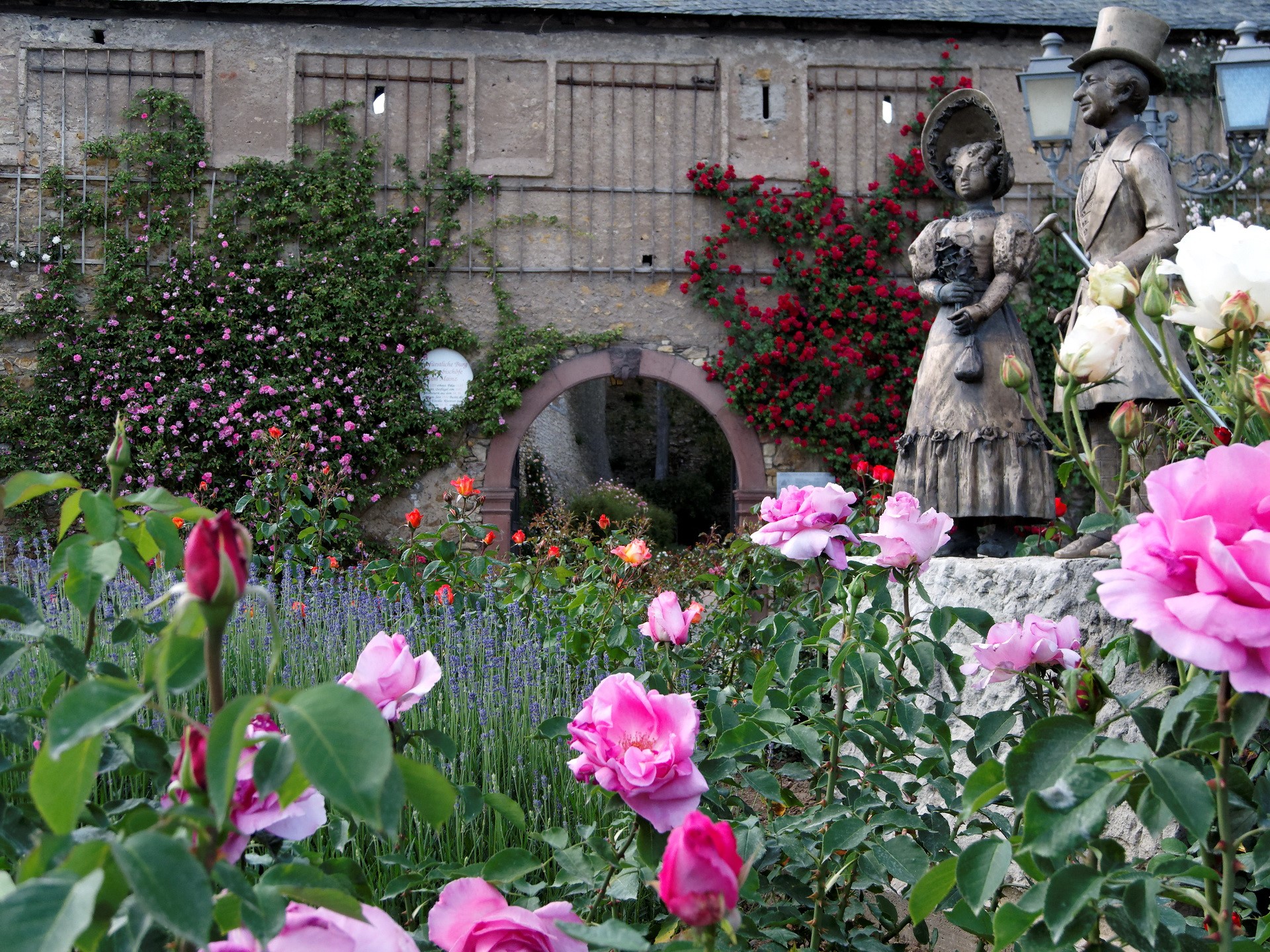 Statues of a couple in a rose garden at Eltville Castle, Germany HD Wallpaper