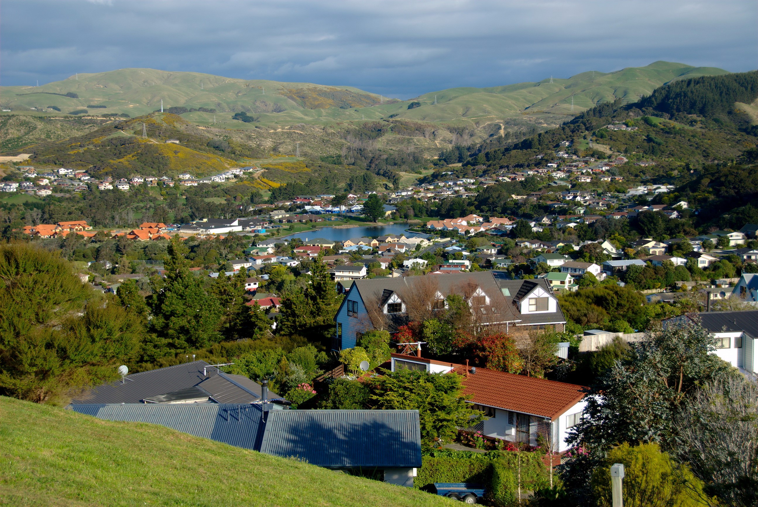 Suburban landscape with hills and a lake in Whitby, New Zealand HD Wallpaper