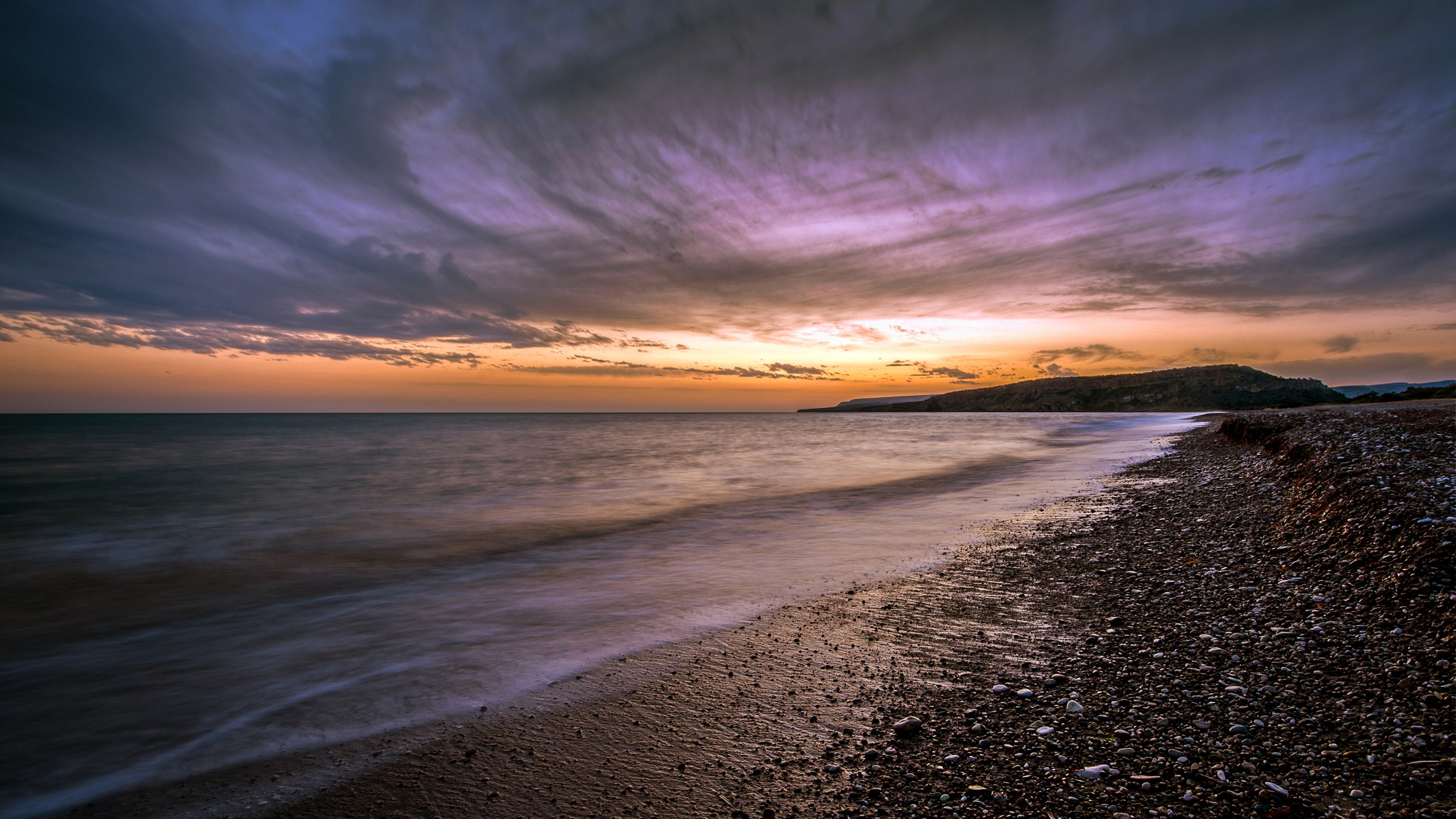 Sunset over a pebble beach and the sea HD Wallpaper