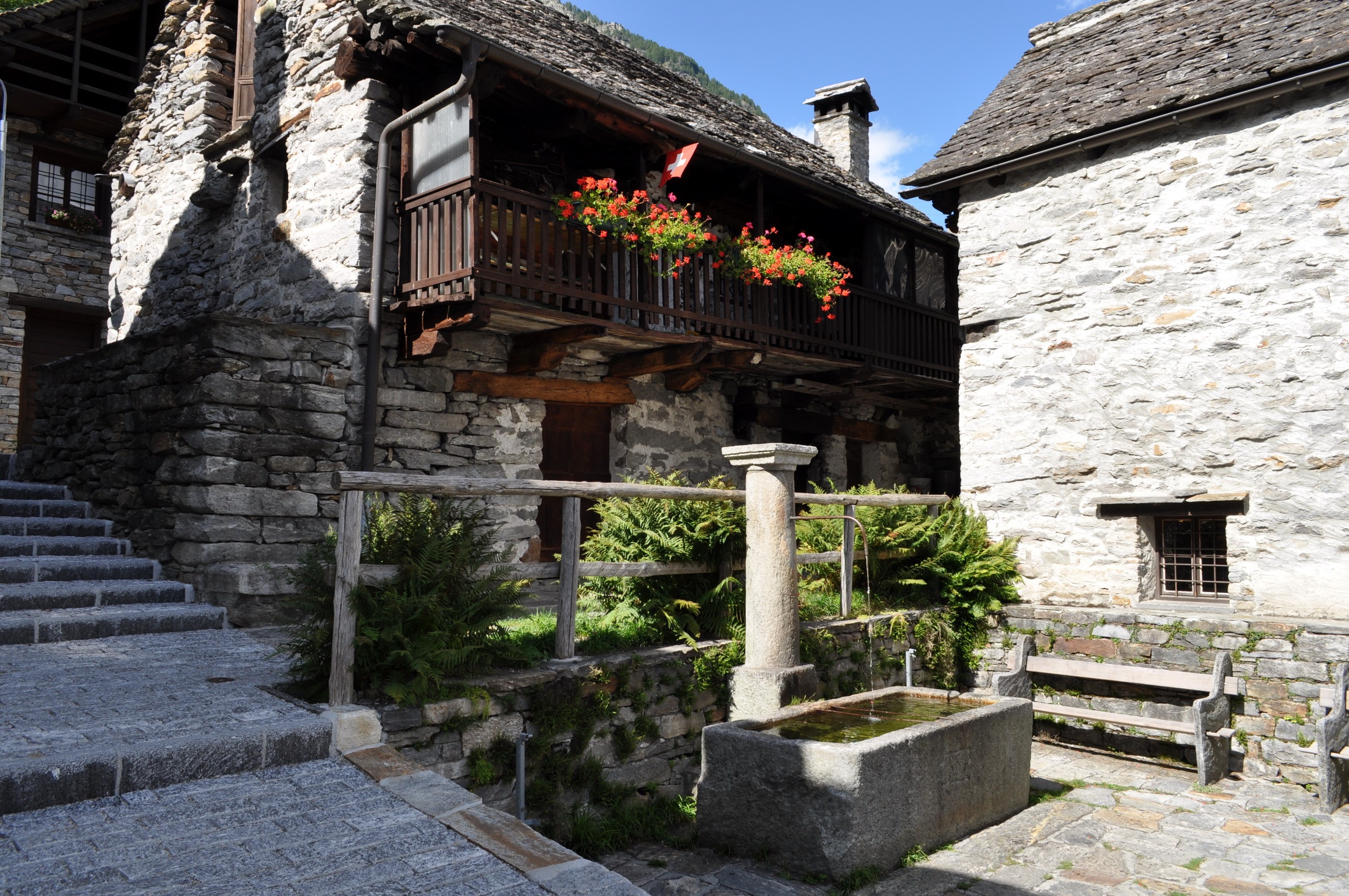 Stone houses with balcony and fountain in Sonogno, Switzerland HD Wallpaper