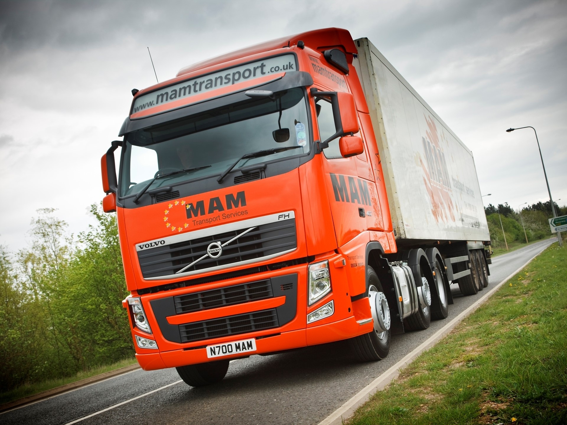 Orange Volvo MAM Transport FH truck on road HD Wallpaper