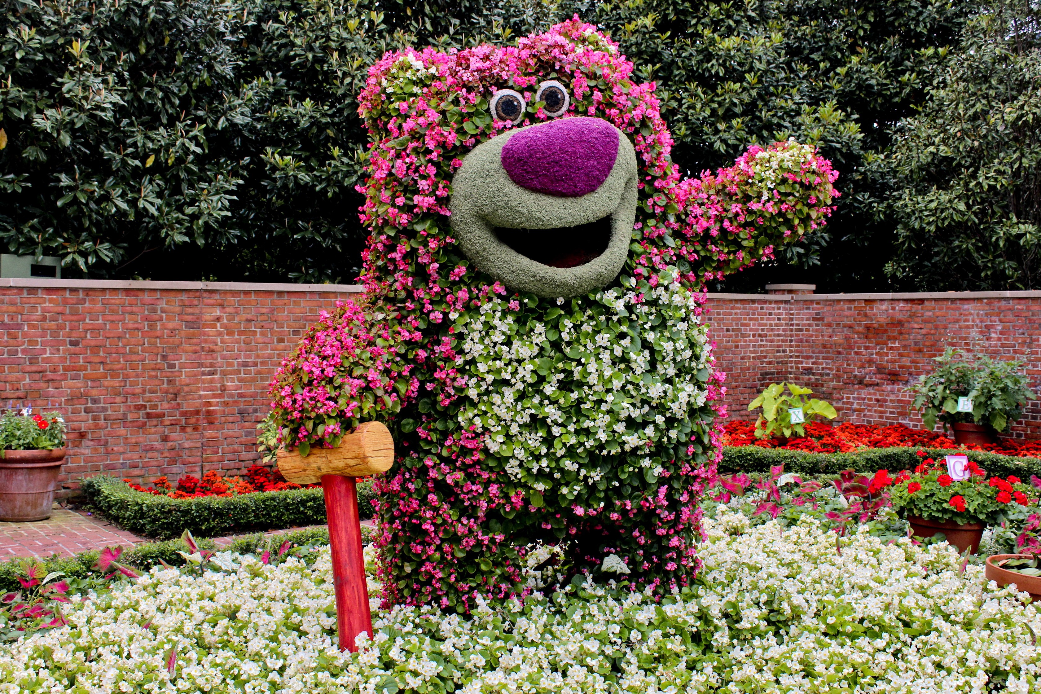 Bear topiary with flowers and a brick wall HD Wallpaper