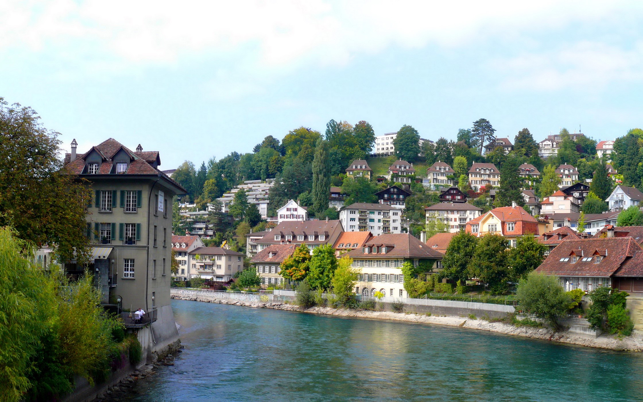 Riverfront buildings on a hillside in Switzerland HD Wallpaper