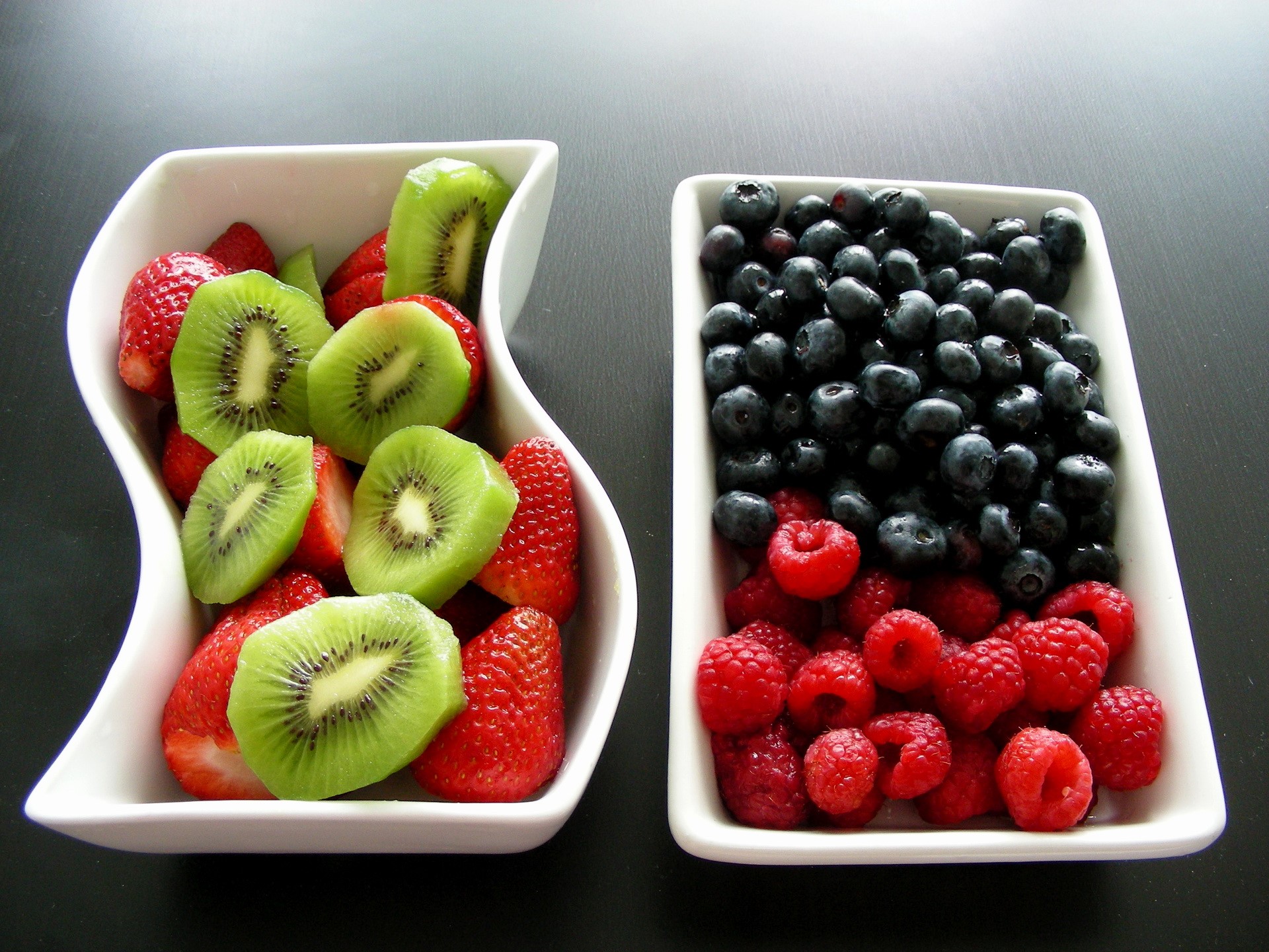 Bowls of fresh fruit: strawberries, kiwi, blueberries, and raspberries HD Wallpaper