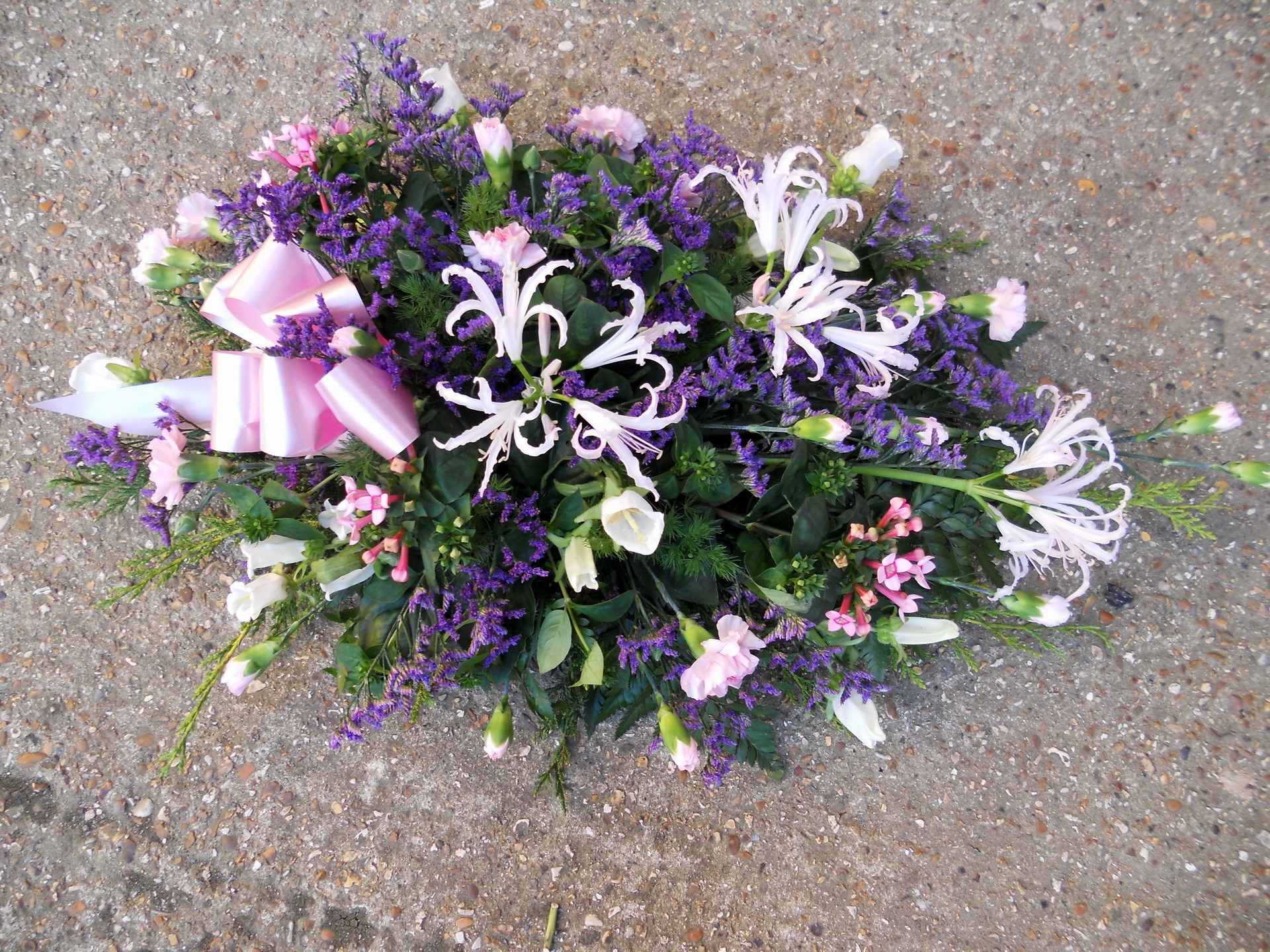 Funeral flower arrangement with pink bow HD Wallpaper