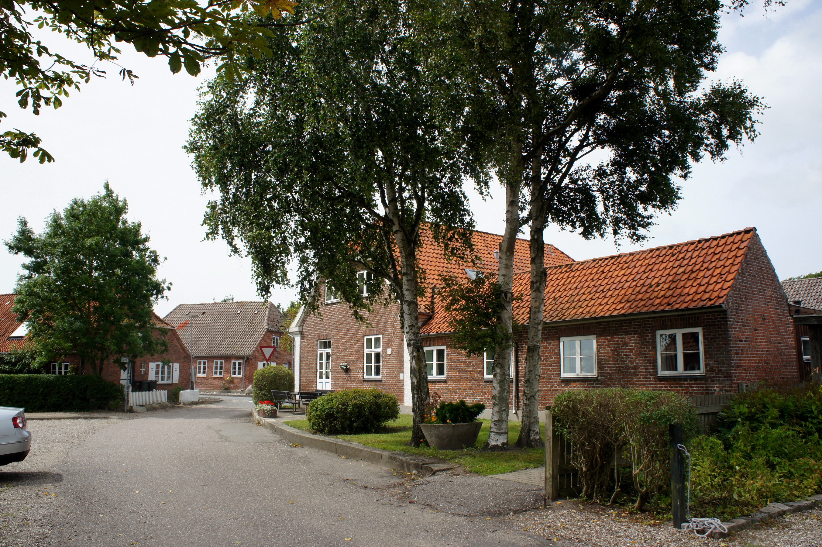Street in Hojer, Denmark with brick houses and trees HD Wallpaper