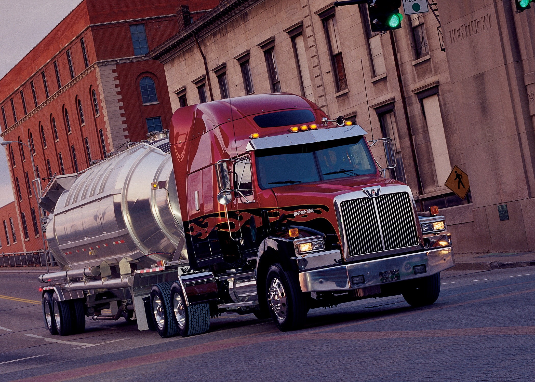 Red Western Star tanker truck driving on a city street HD Wallpaper