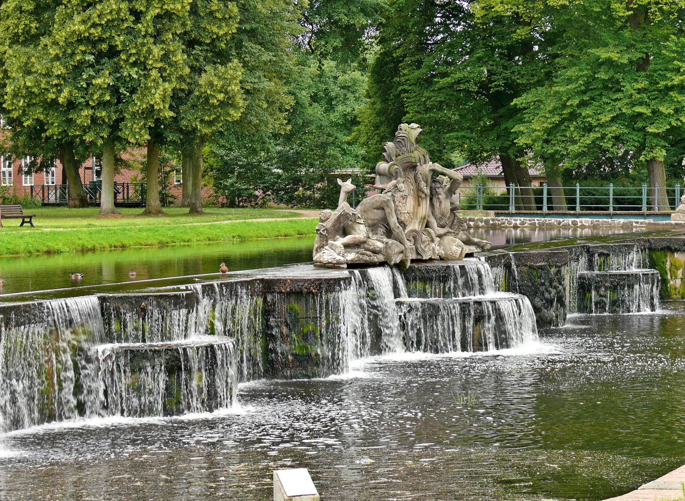 Sculpture and waterfall in a park HD Wallpaper