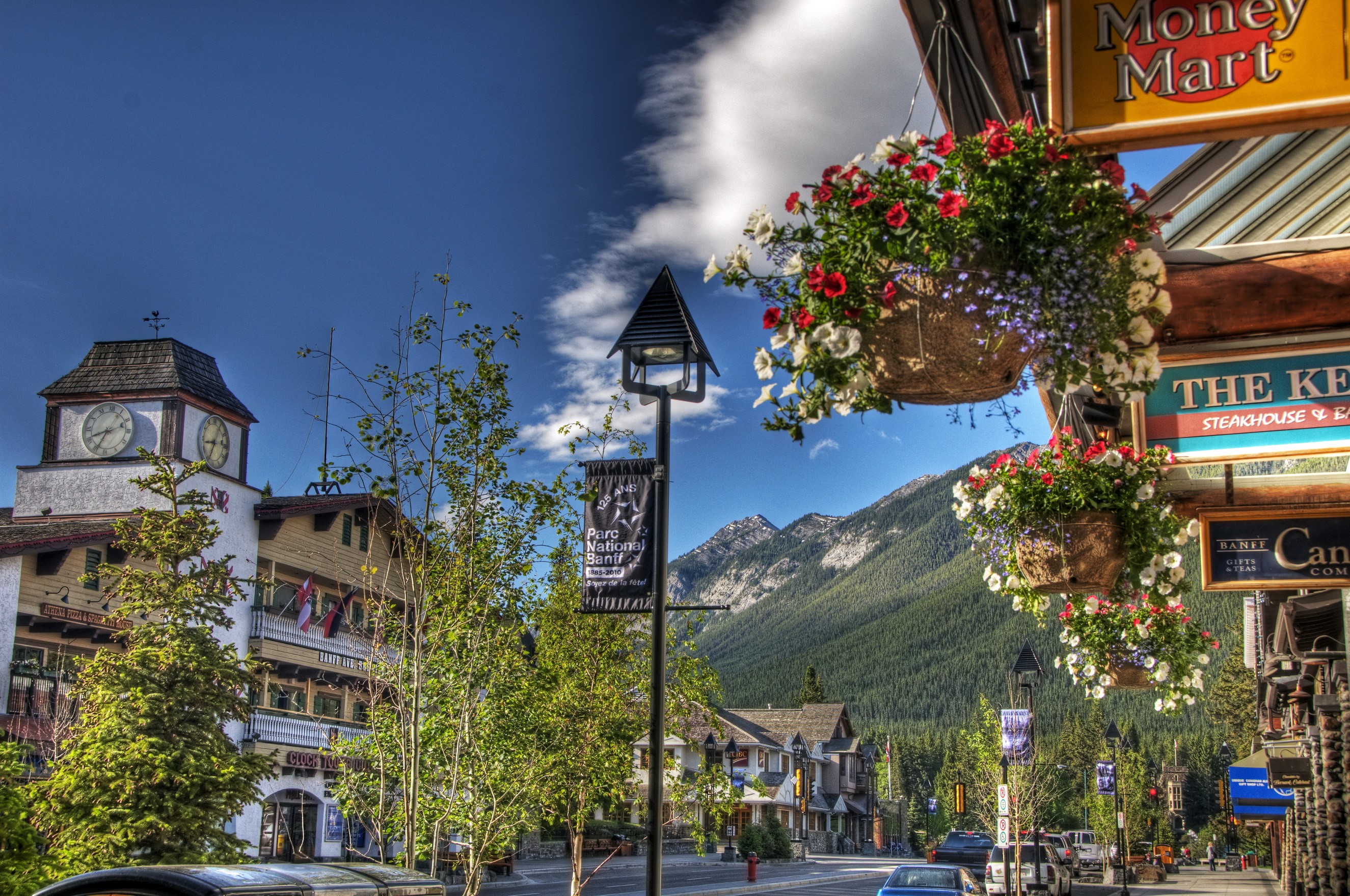 Street scene in Banff, Canada with mountains and clock tower HD Wallpaper