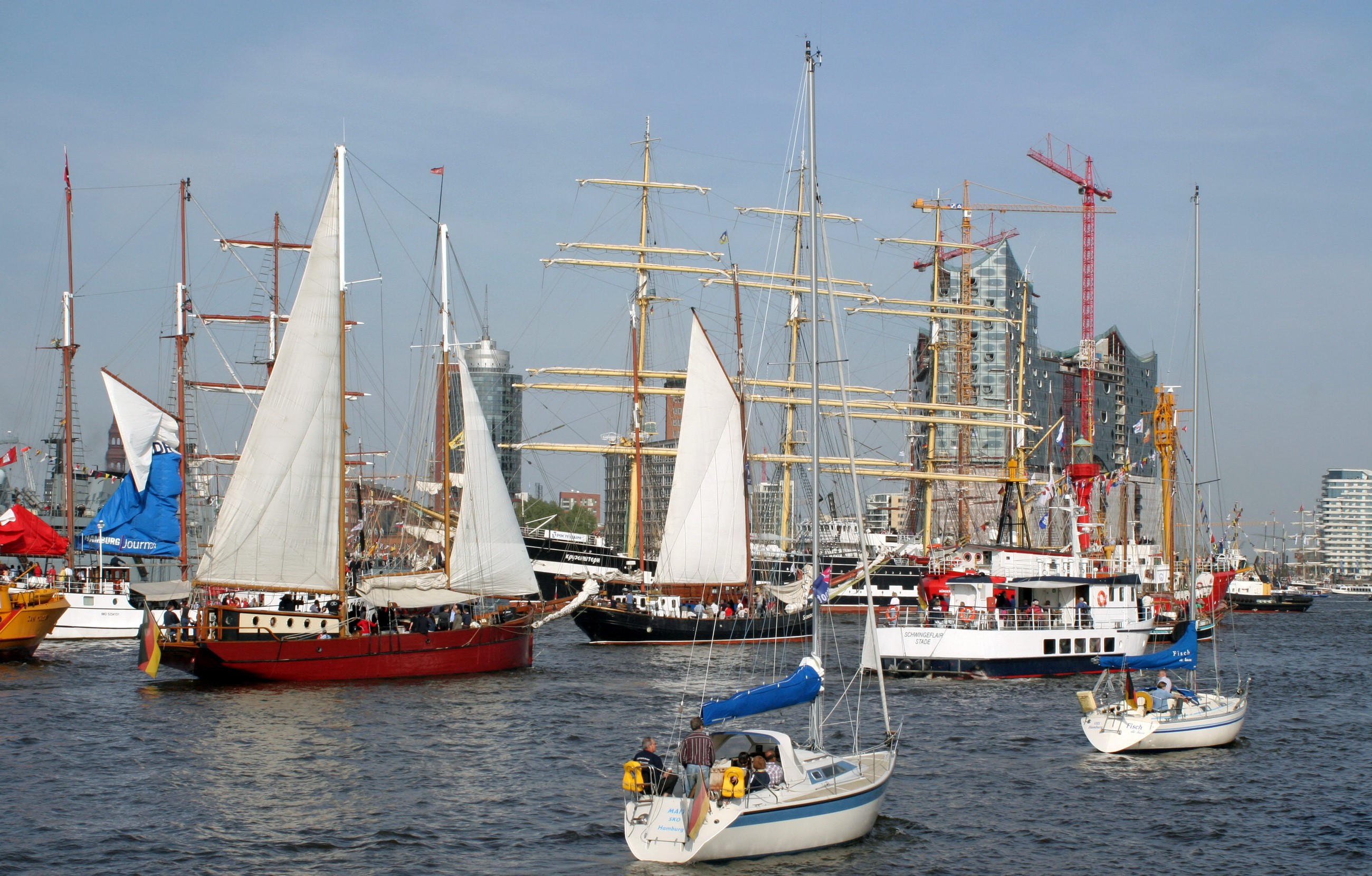 Tall ships and sailboats in a harbor with city skyline HD Wallpaper