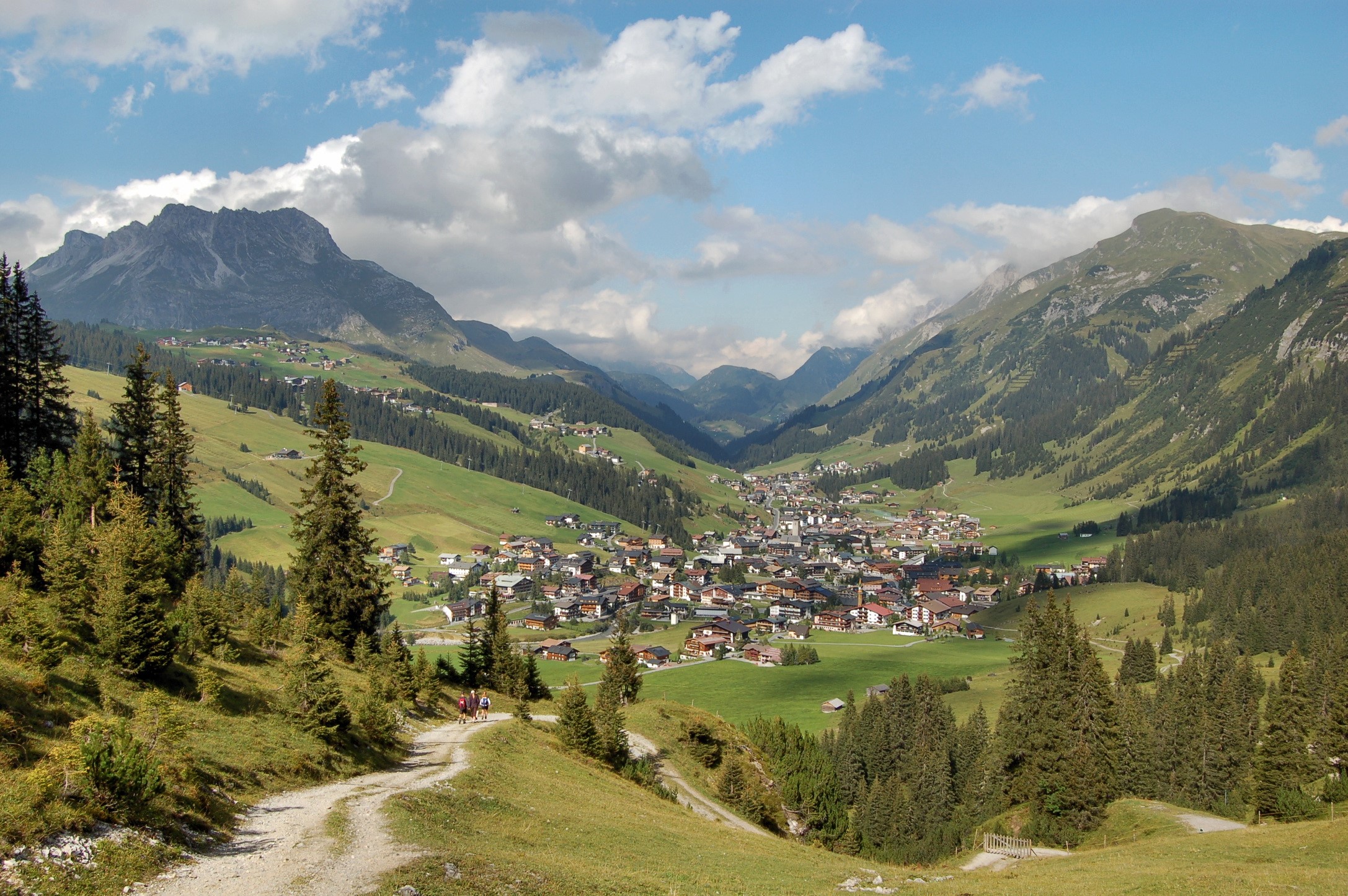 Alpine village nestled in a mountain valley HD Wallpaper