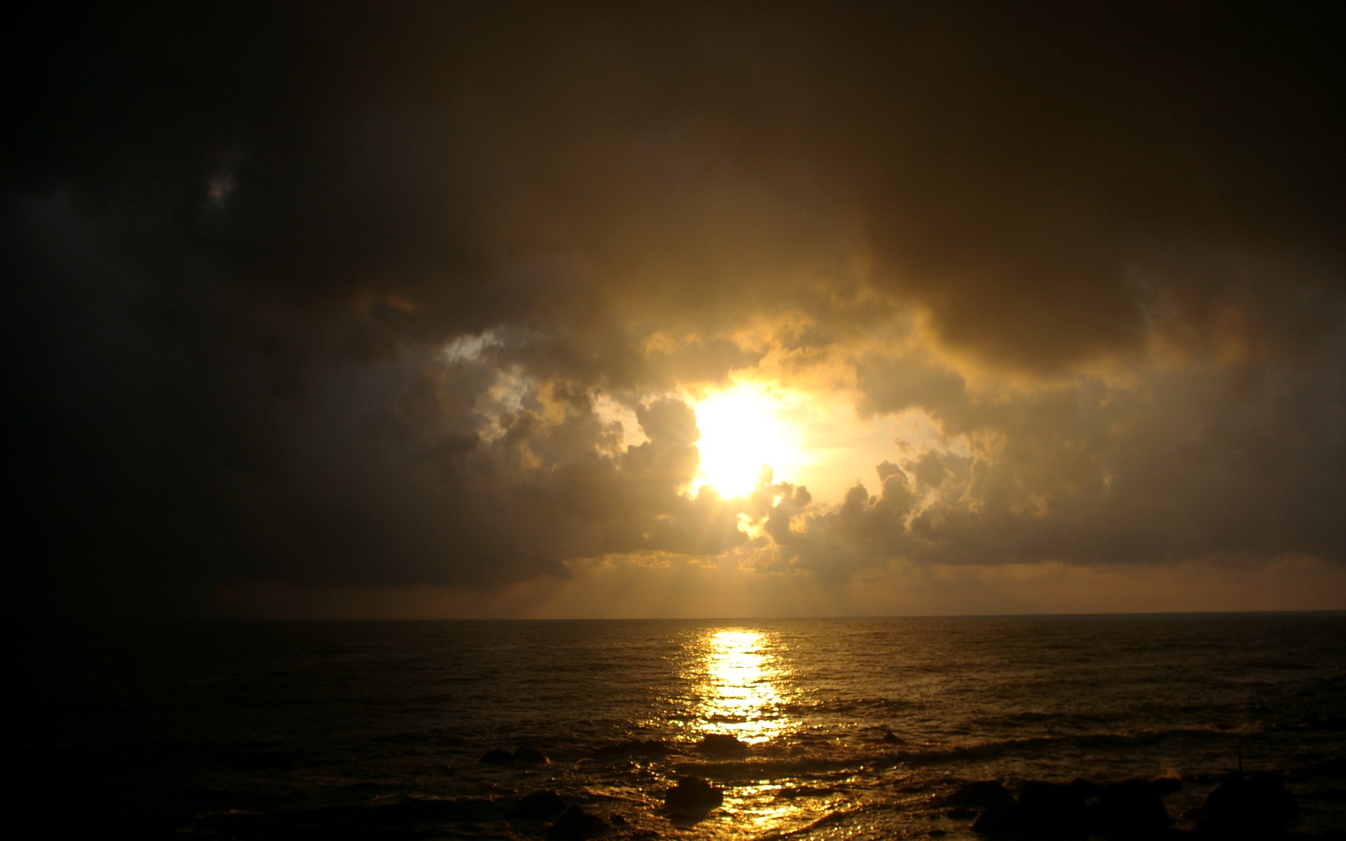 Sunset over the ocean with dark clouds HD Wallpaper