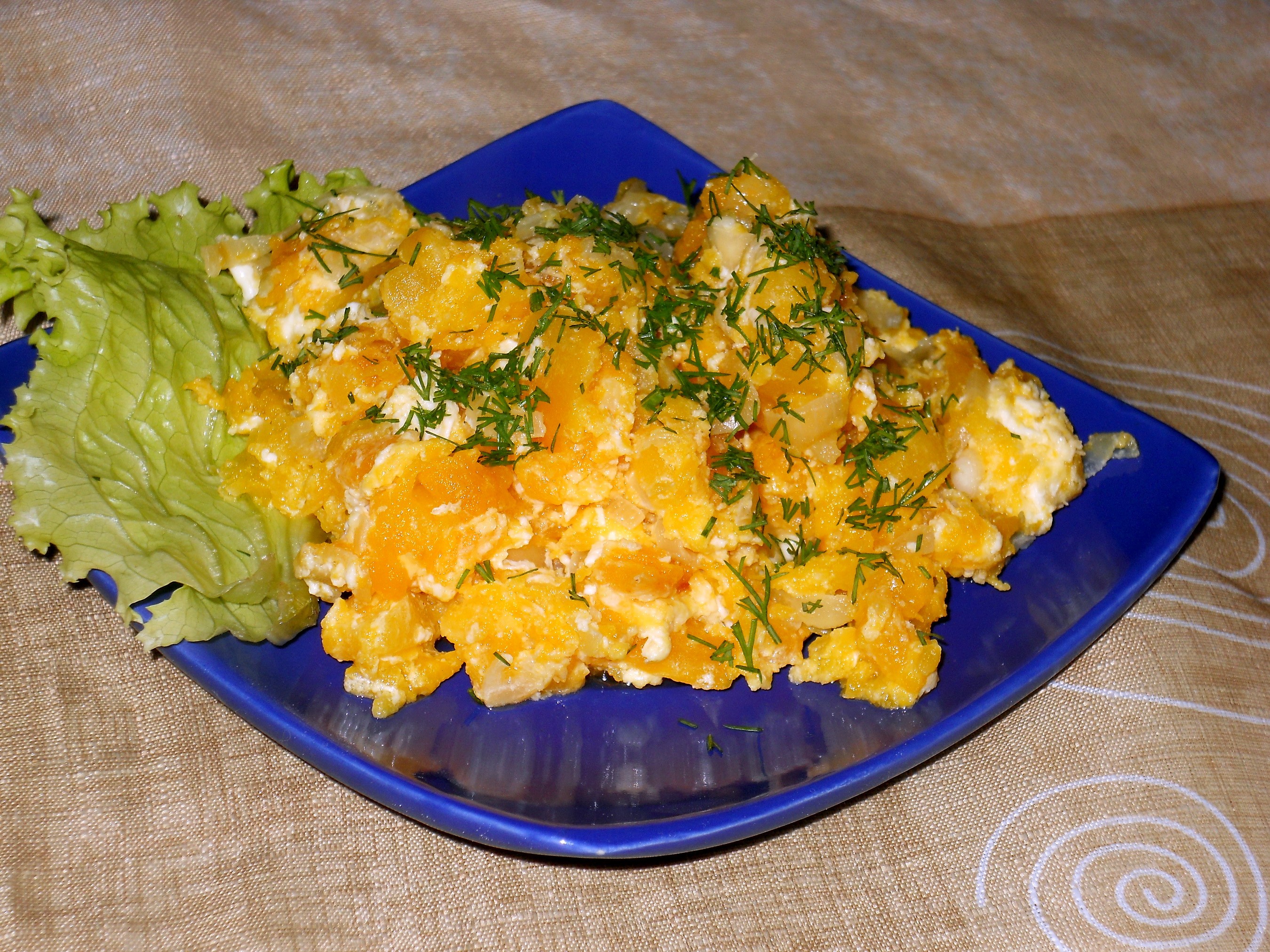 Scrambled eggs with pumpkin and dill on a blue plate HD Wallpaper