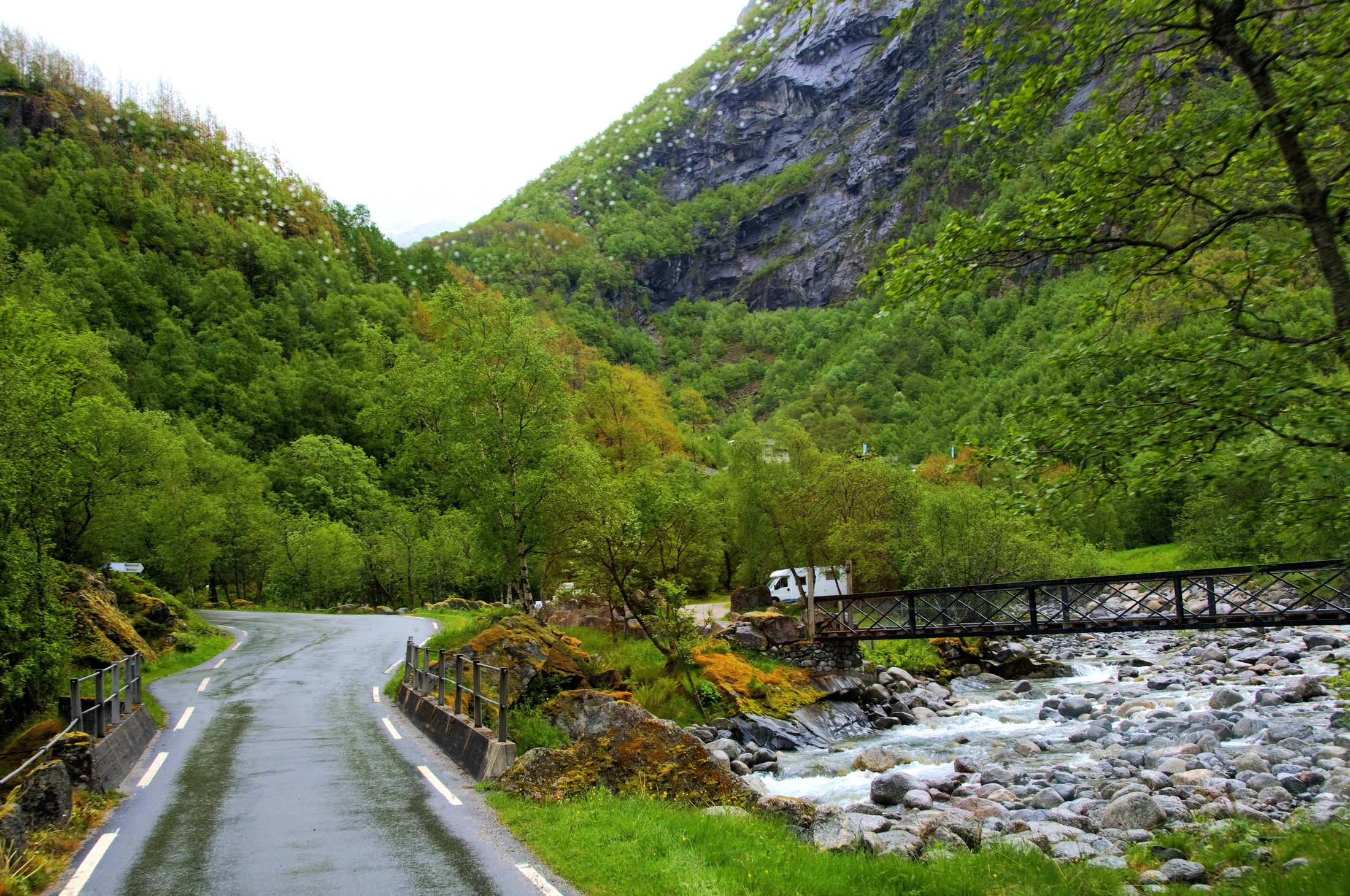 Road through a green mountain valley with a river and bridge HD Wallpaper