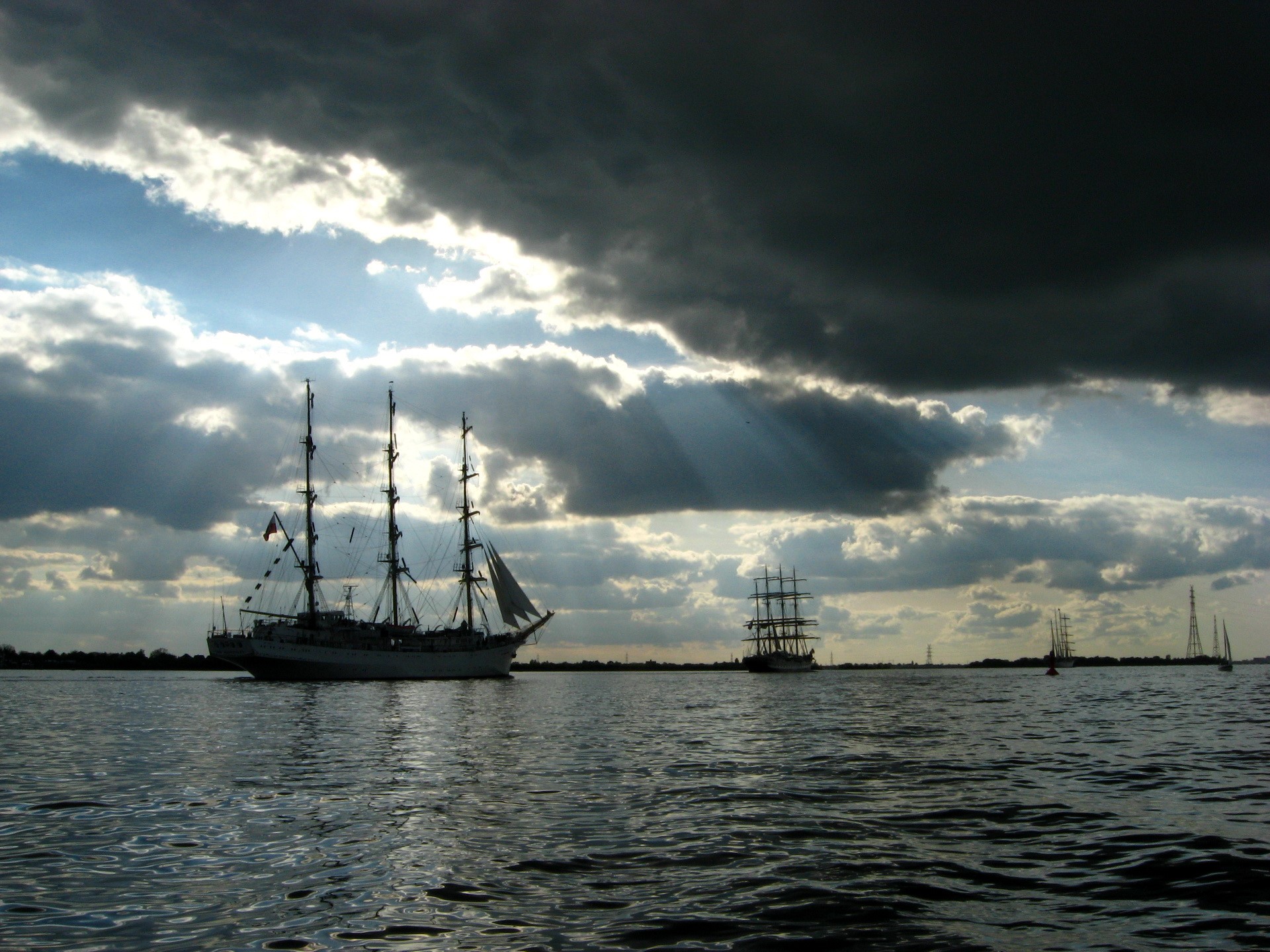 Tall ships sailing on the water under dramatic clouds HD Wallpaper