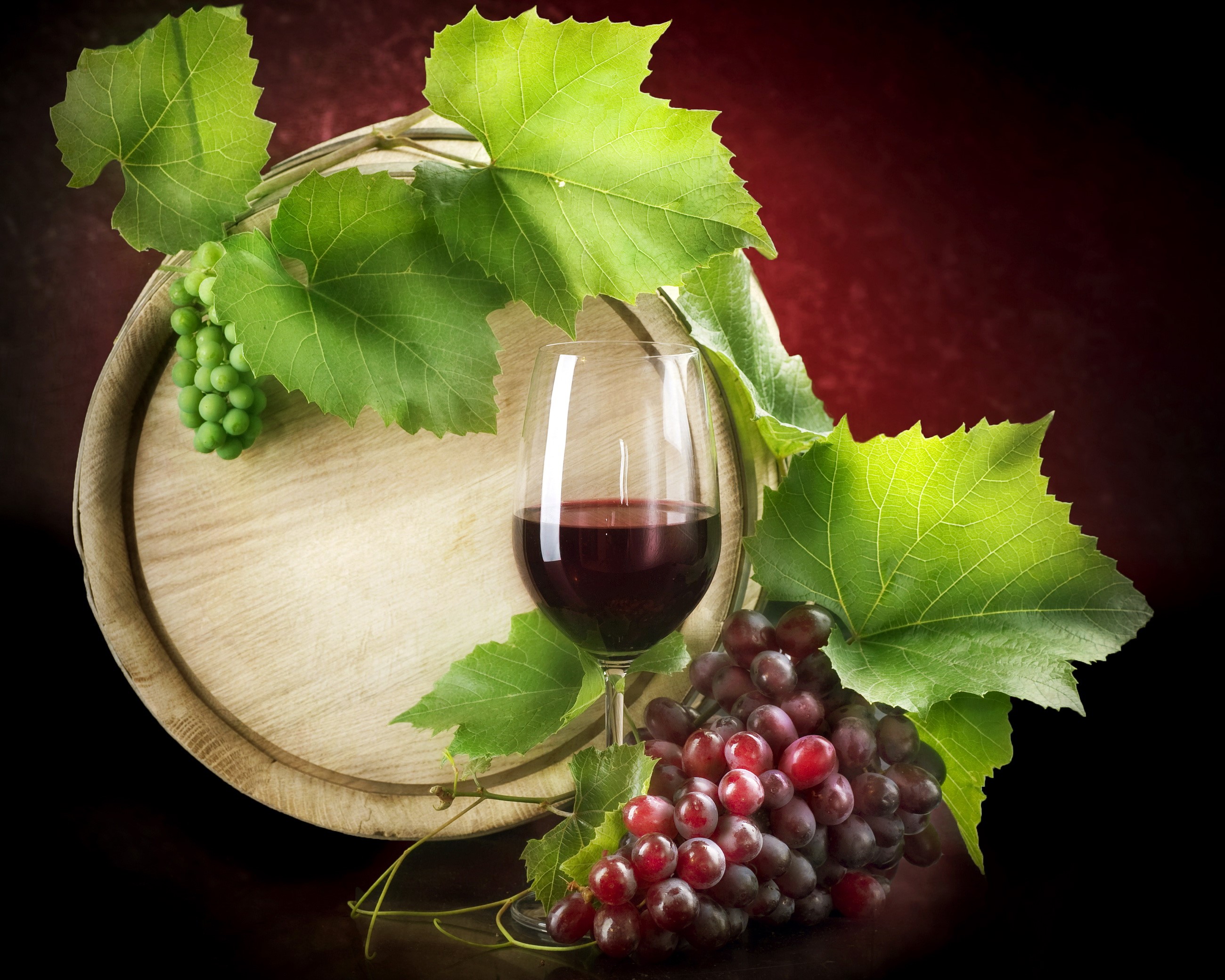 Red wine in a glass with grapes and a barrel HD Wallpaper