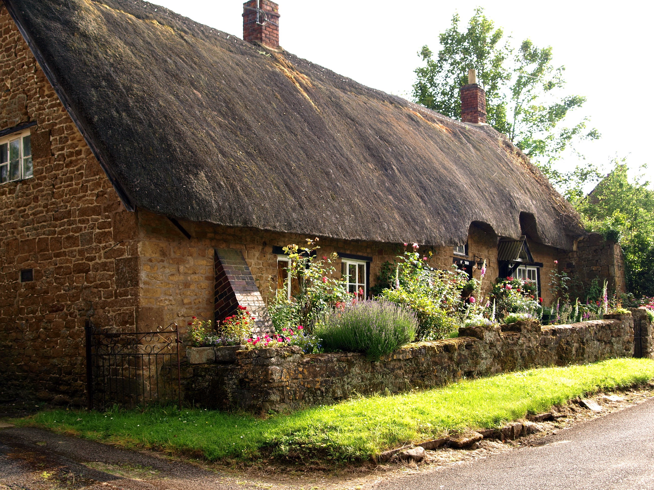 Thatched cottage with stone walls and garden HD Wallpaper