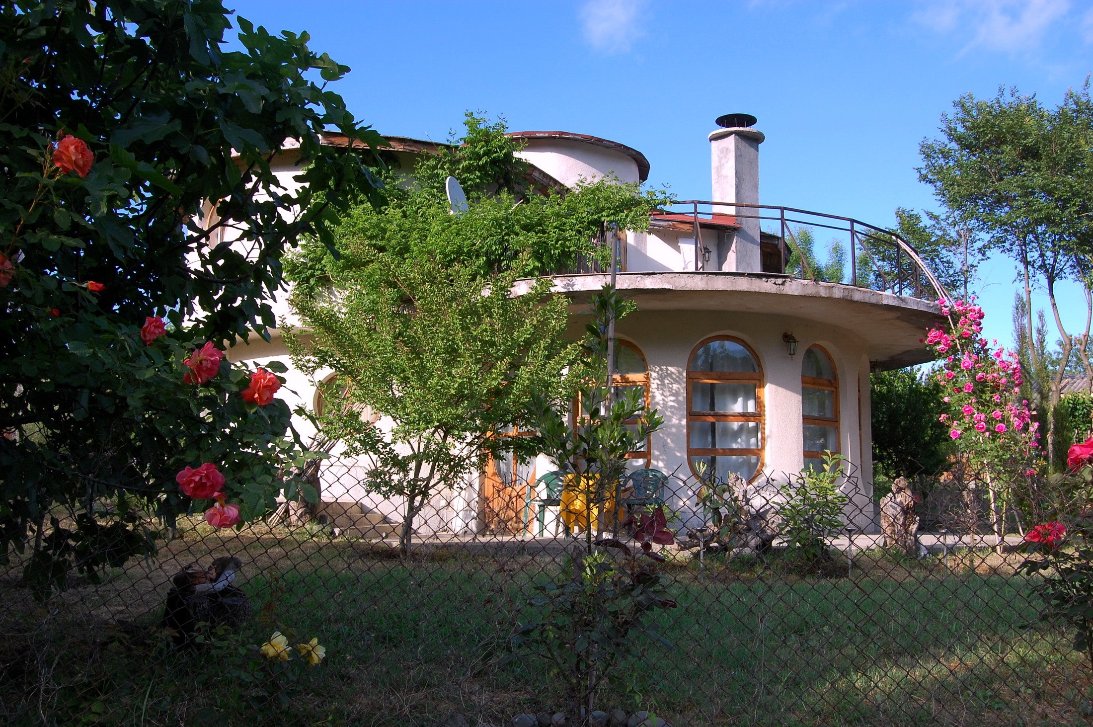 Curved house with roses in Bulgaria HD Wallpaper