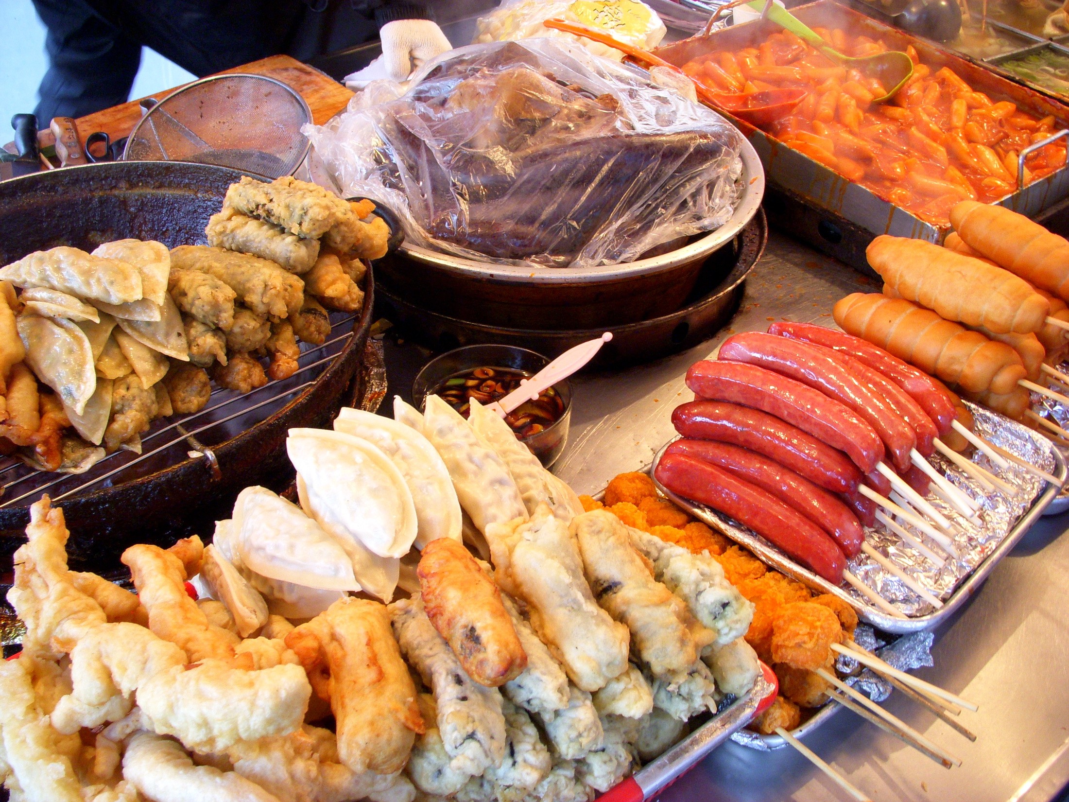 Korean street food stall with fried snacks and sausages HD Wallpaper