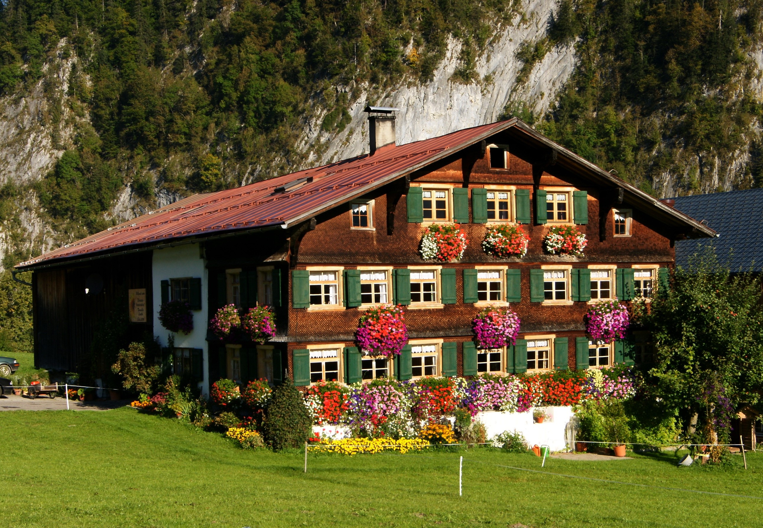 Alpine house with flowers in Argenau, Austria HD Wallpaper