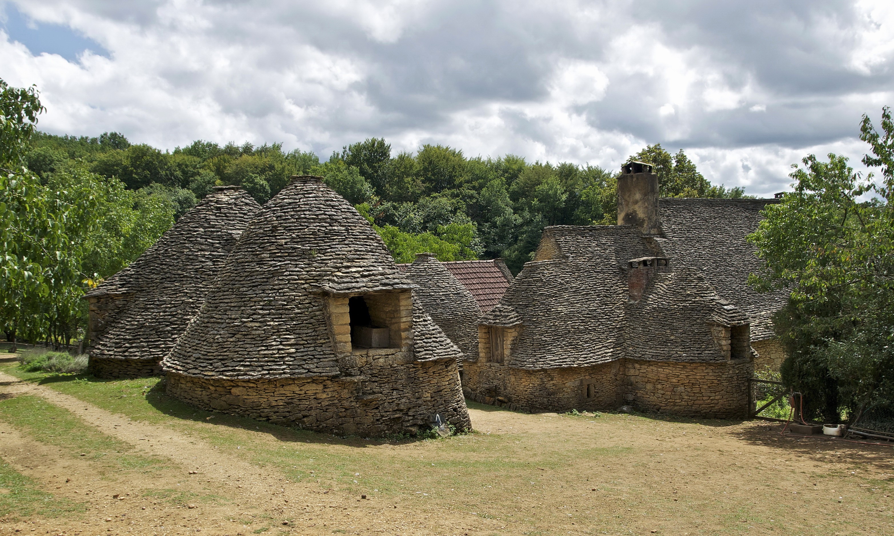 Stone houses with conical roofs in a rural village HD Wallpaper
