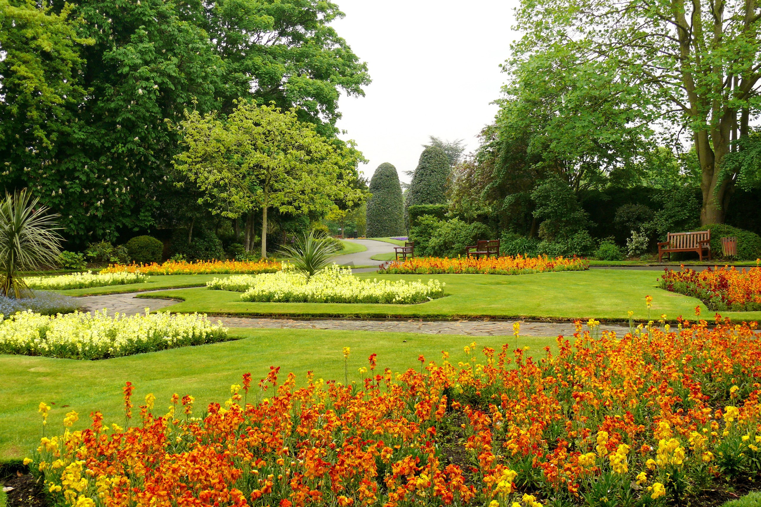 A beautiful park with flower beds and trees HD Wallpaper