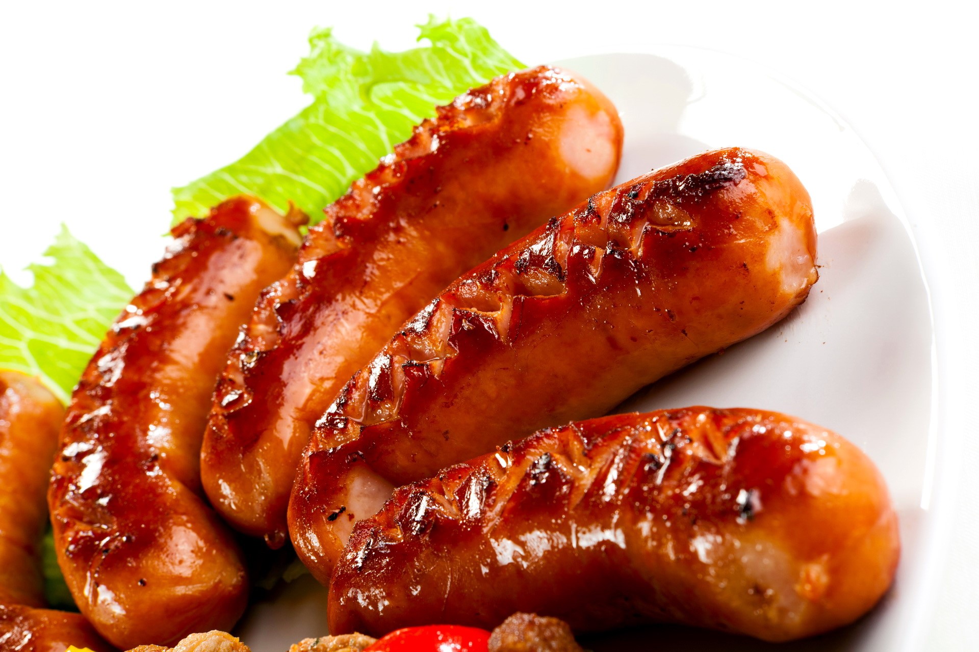 Grilled sausages on a white plate with lettuce HD Wallpaper