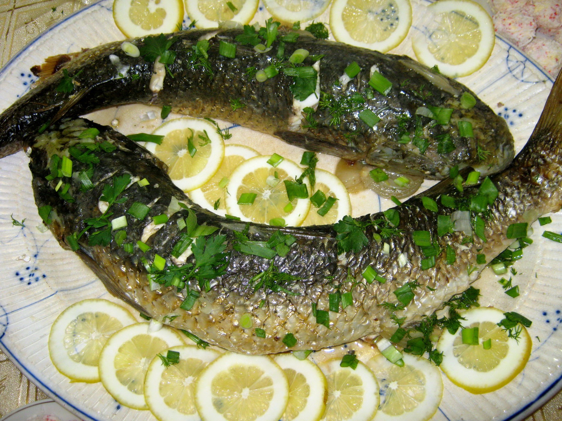 Two whole cooked fish garnished with lemon and herbs HD Wallpaper