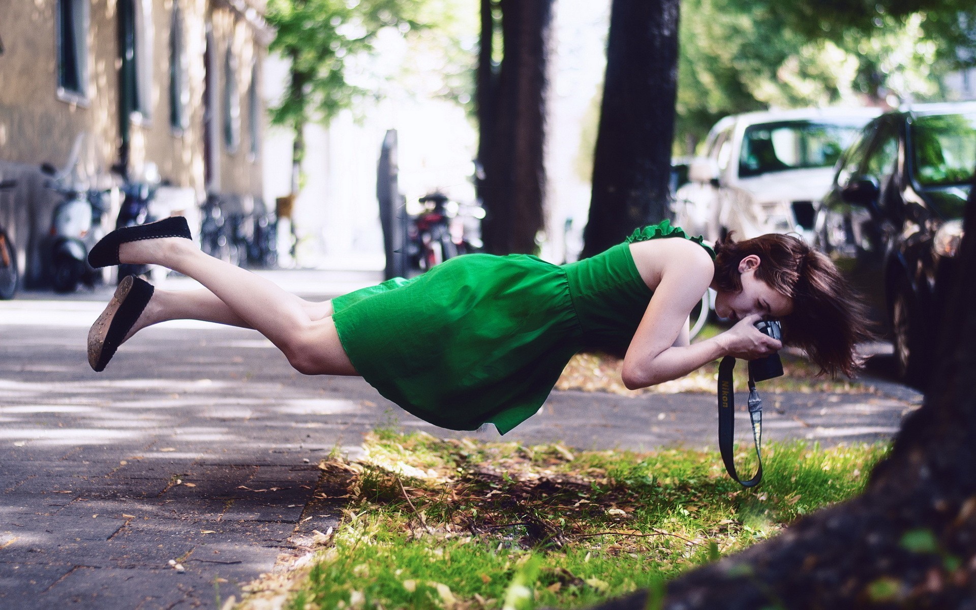 Woman in green dress levitating while taking a photo HD Wallpaper