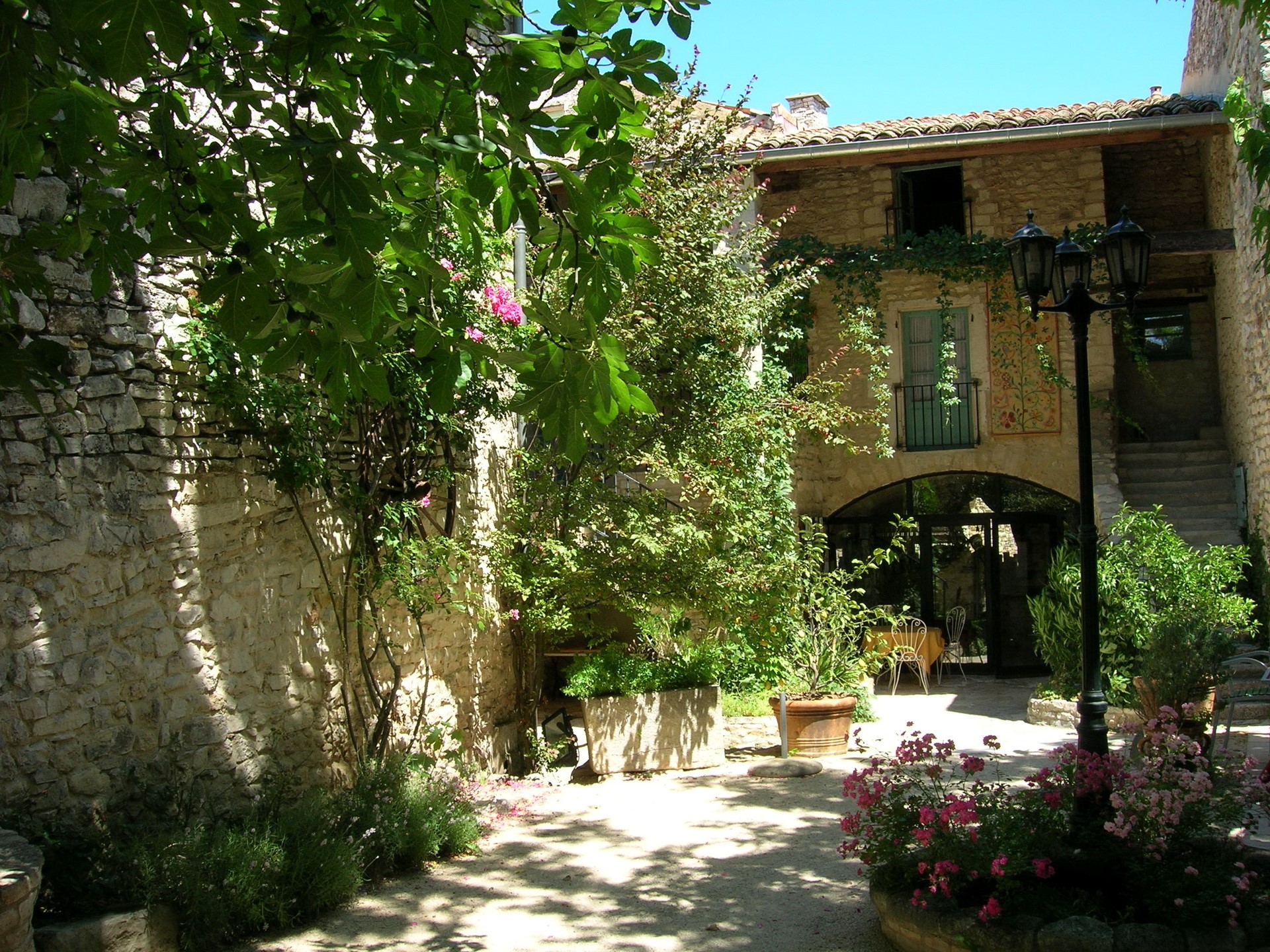 Courtyard with stone building and flowers in France HD Wallpaper