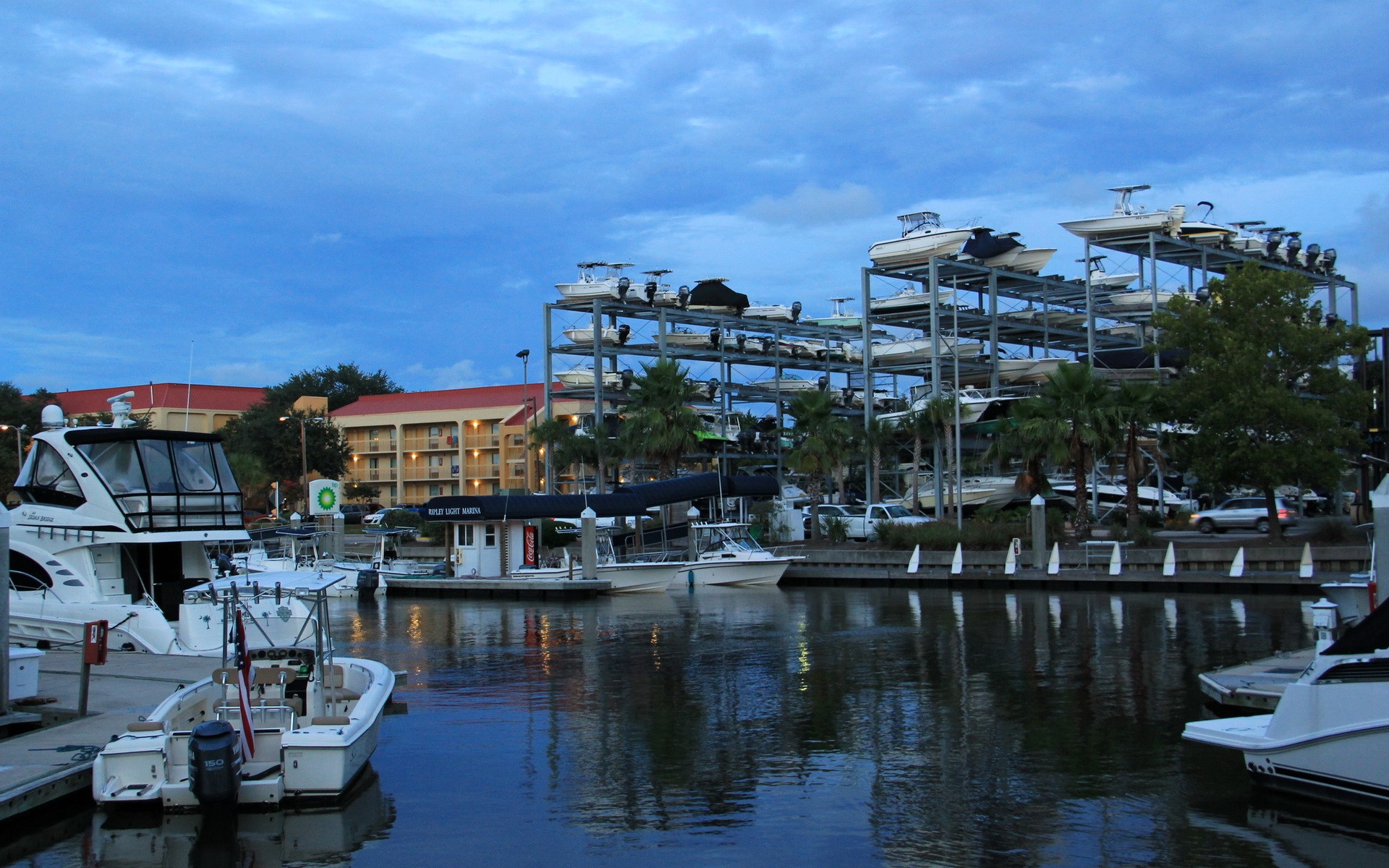Boats docked at a marina with a boat storage rack HD Wallpaper
