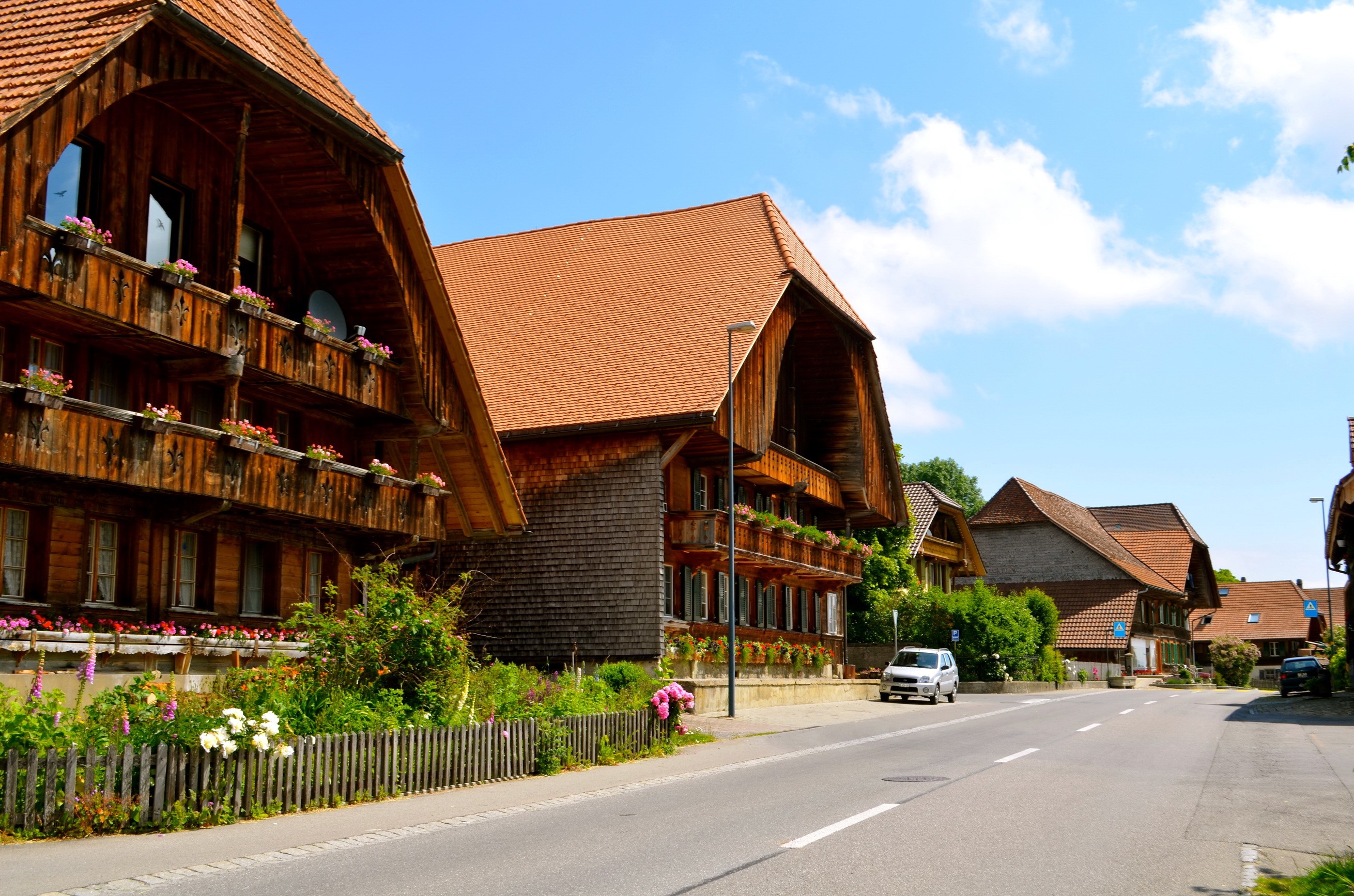 Traditional wooden houses on a street in Rueggisberg, Switzerland HD Wallpaper
