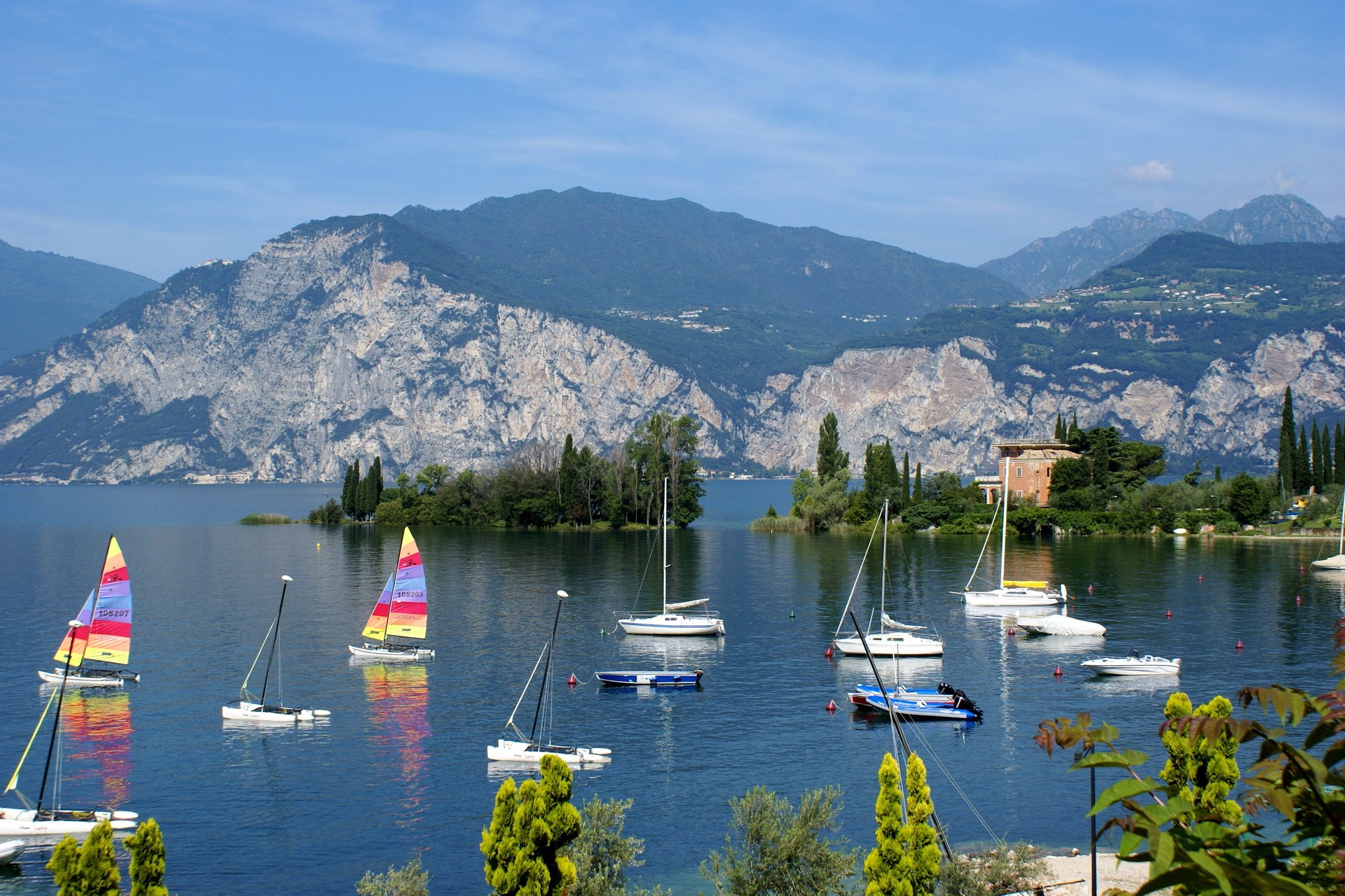 Sailboats on a lake with mountains in the background HD Wallpaper