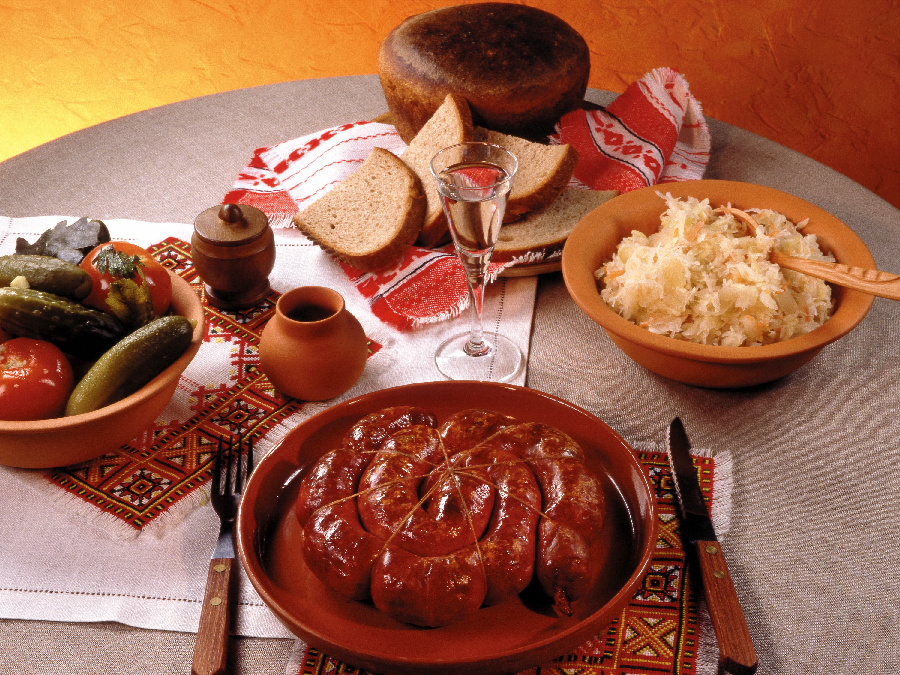 Sausage, pickles, sauerkraut, bread, and vodka on a table HD Wallpaper