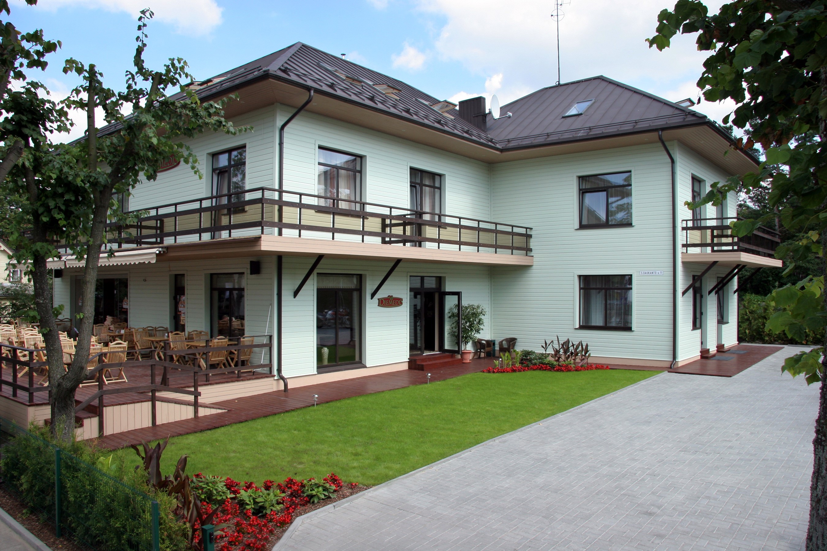 Light green building with balconies and outdoor seating HD Wallpaper