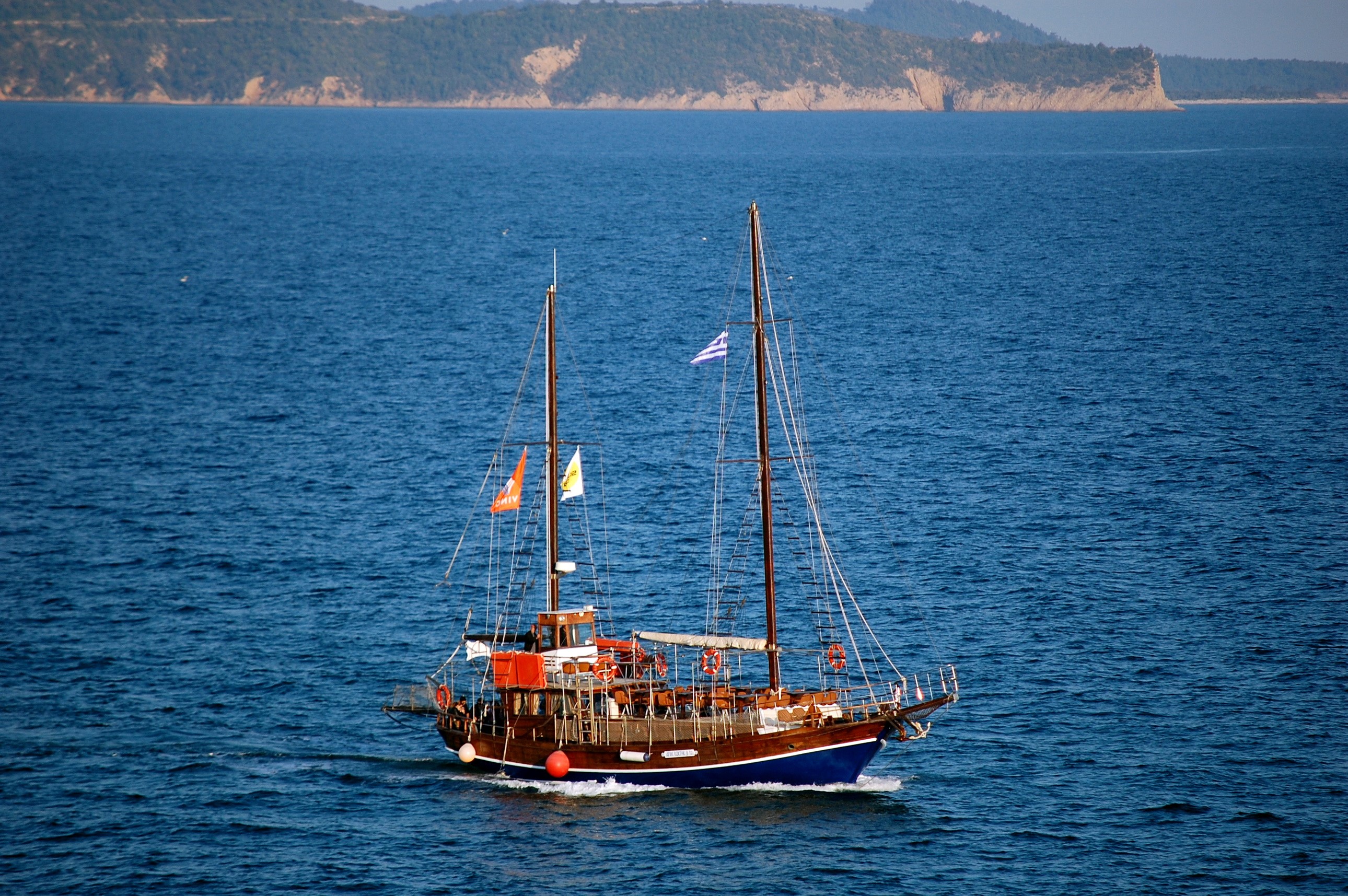 Wooden sailing ship with flags on blue water HD Wallpaper