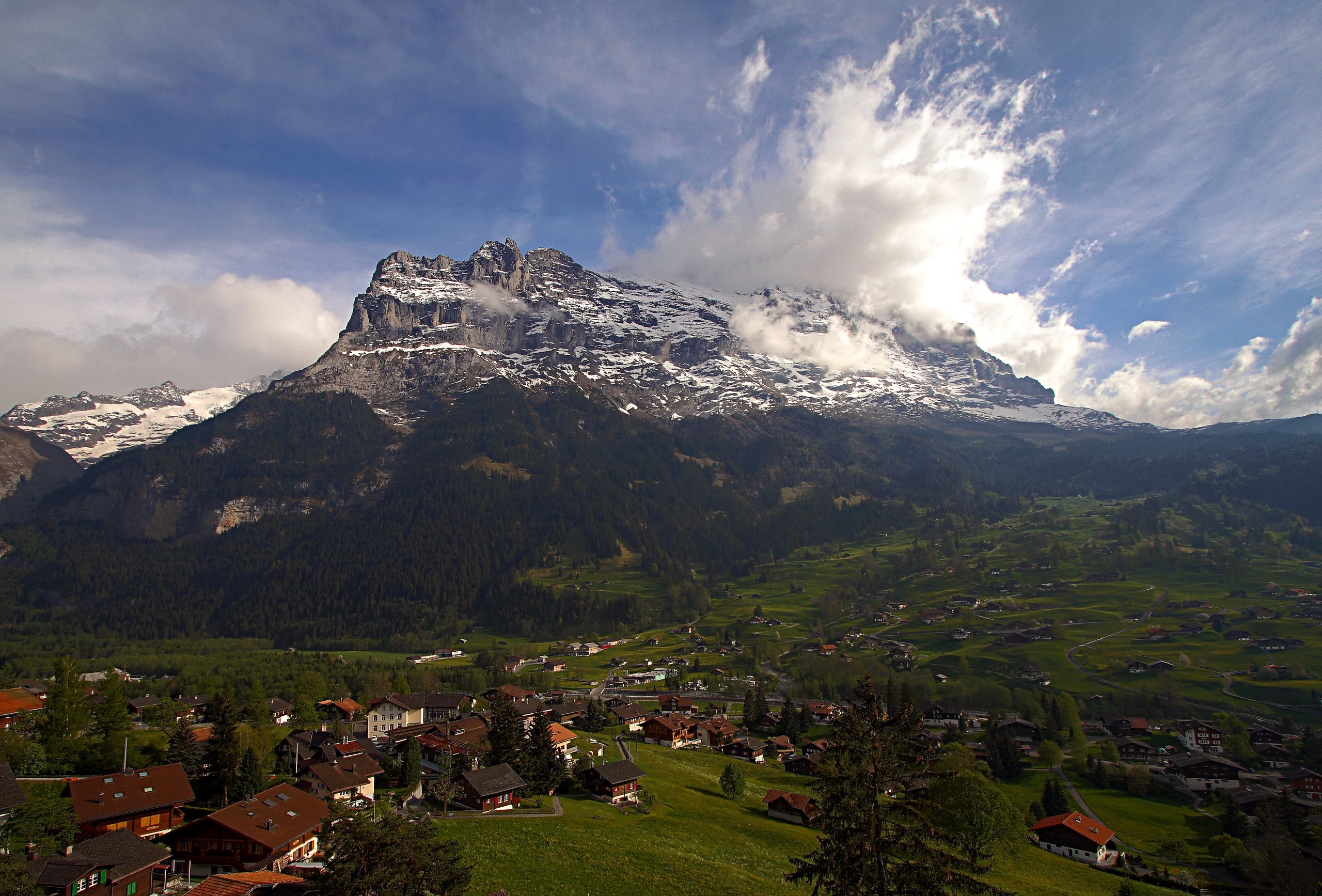 Mount Eiger in Switzerland with a village below HD Wallpaper