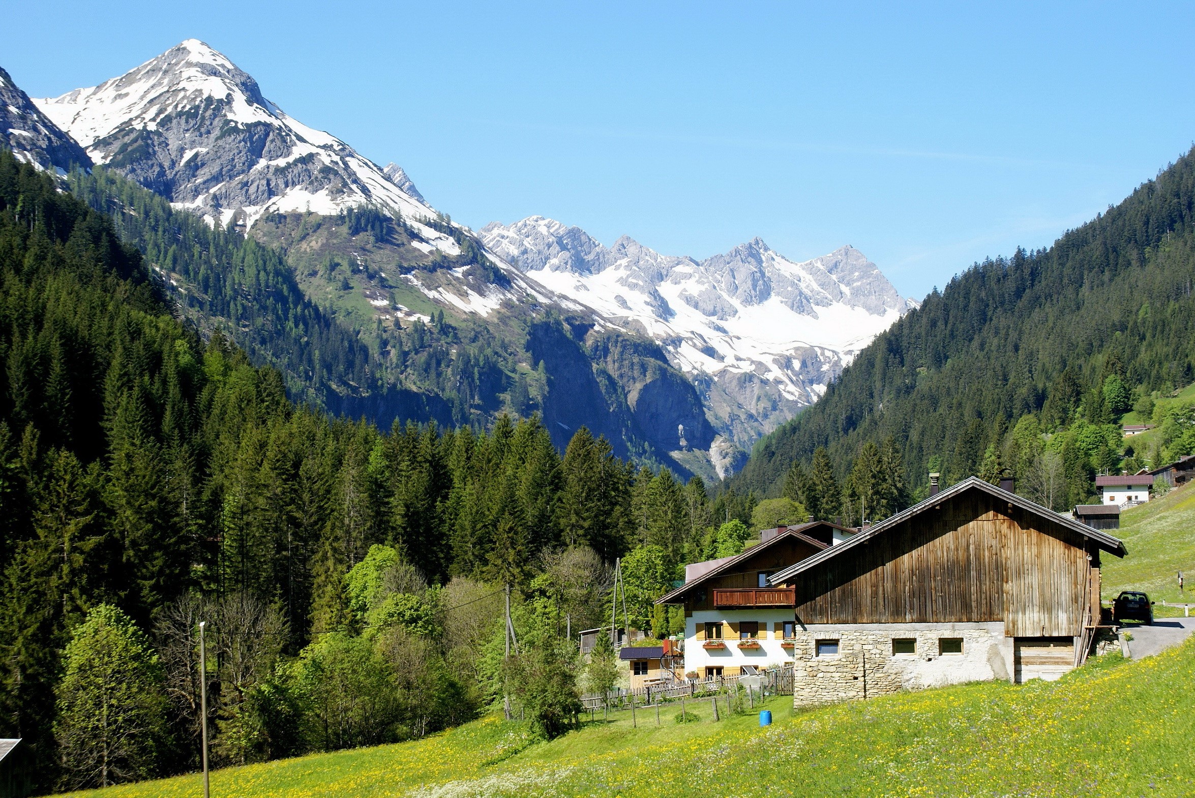 Alpine village with snow-capped mountains in Austria HD Wallpaper